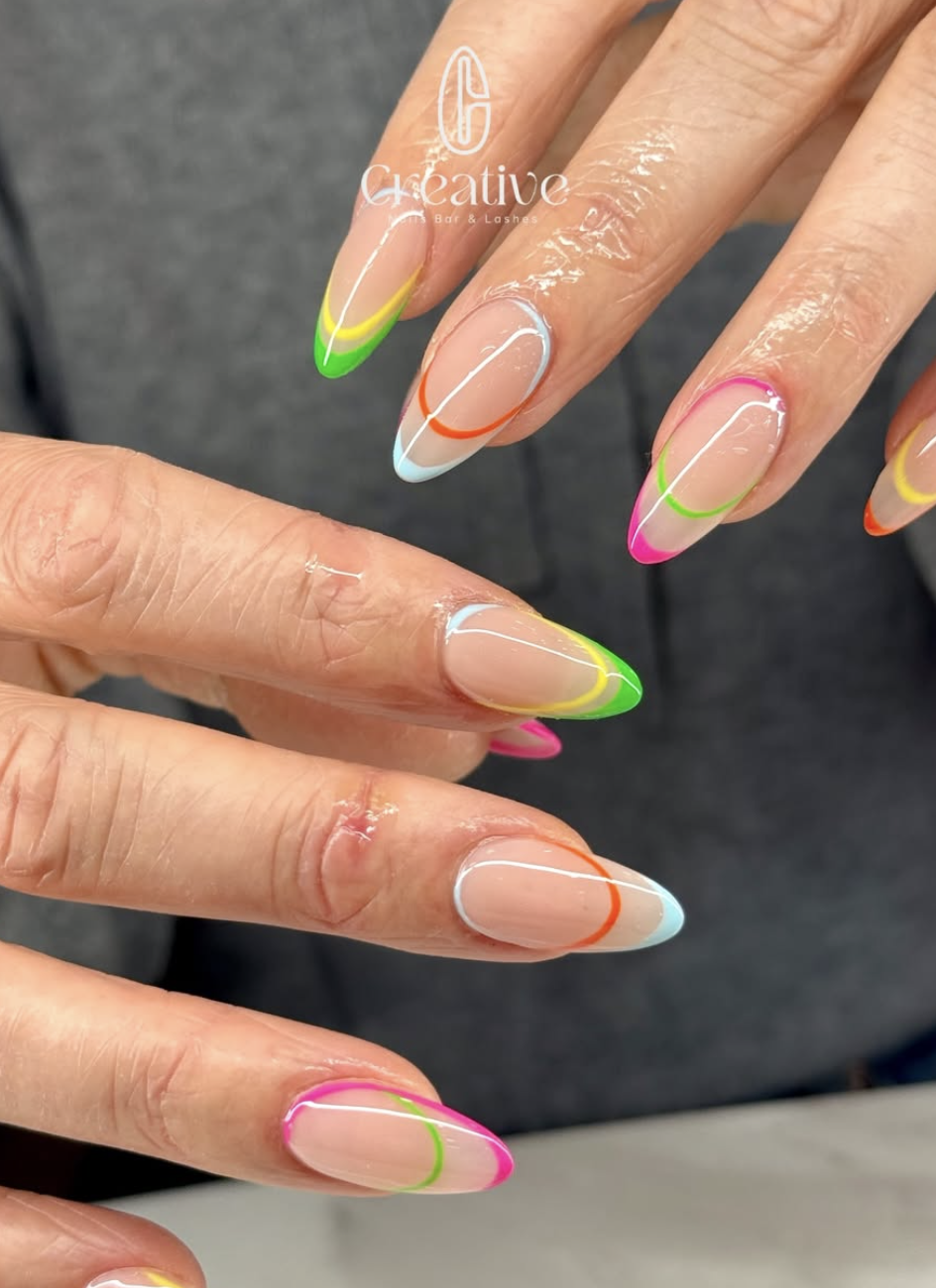 Colorful neon French manicure with pink, orange, yellow, green, and blue tips on natural nails, with a clear base and white lines.