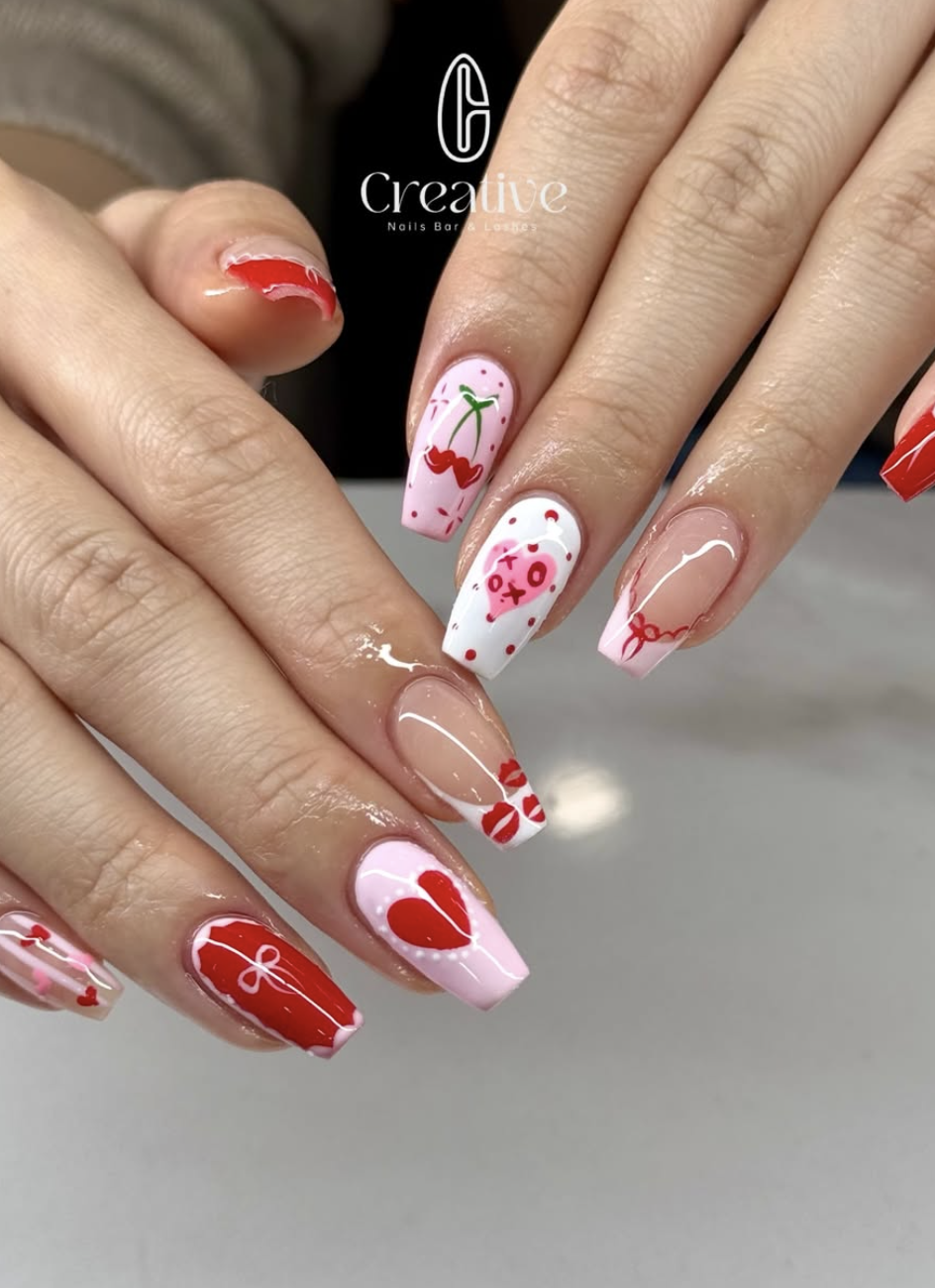 Manicure with Valentine's Day themed nail art featuring hearts, kisses, and red, pink, and white colors.