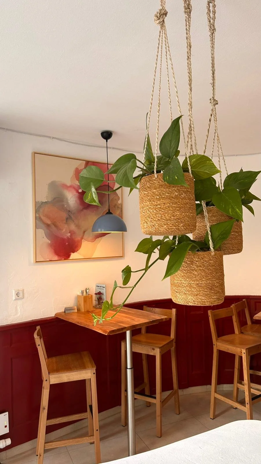Collection of contemporary abstract artworks by Denize Jung presented at Café Nusa Weinheim, featuring layered paintings inspired by Mediterranean living and natural tones.