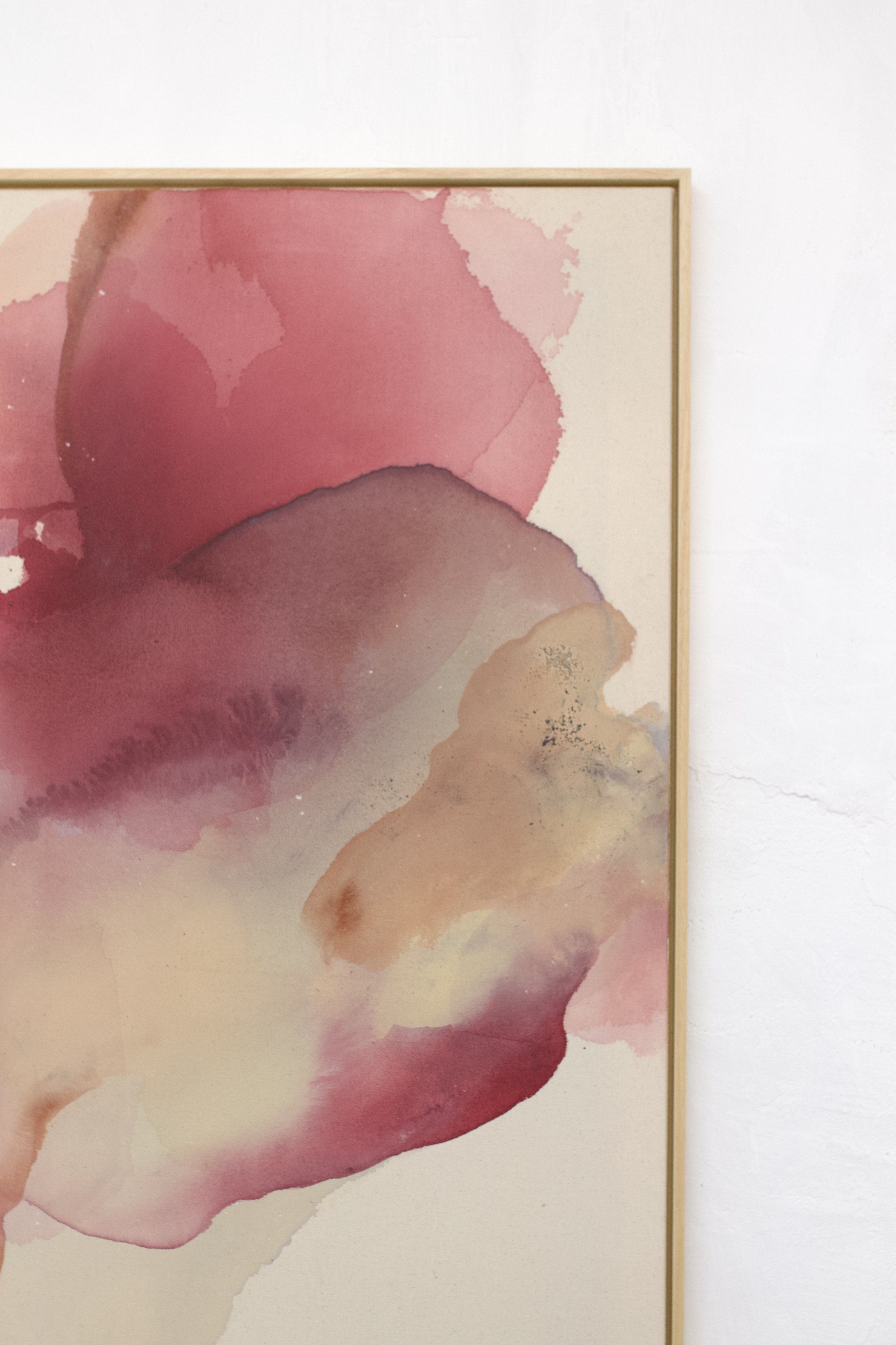 Abstraktes Wasserfarbenbild mit floralen Pink- und Lavatönen, gerahmt in Holz, an weißer Wand