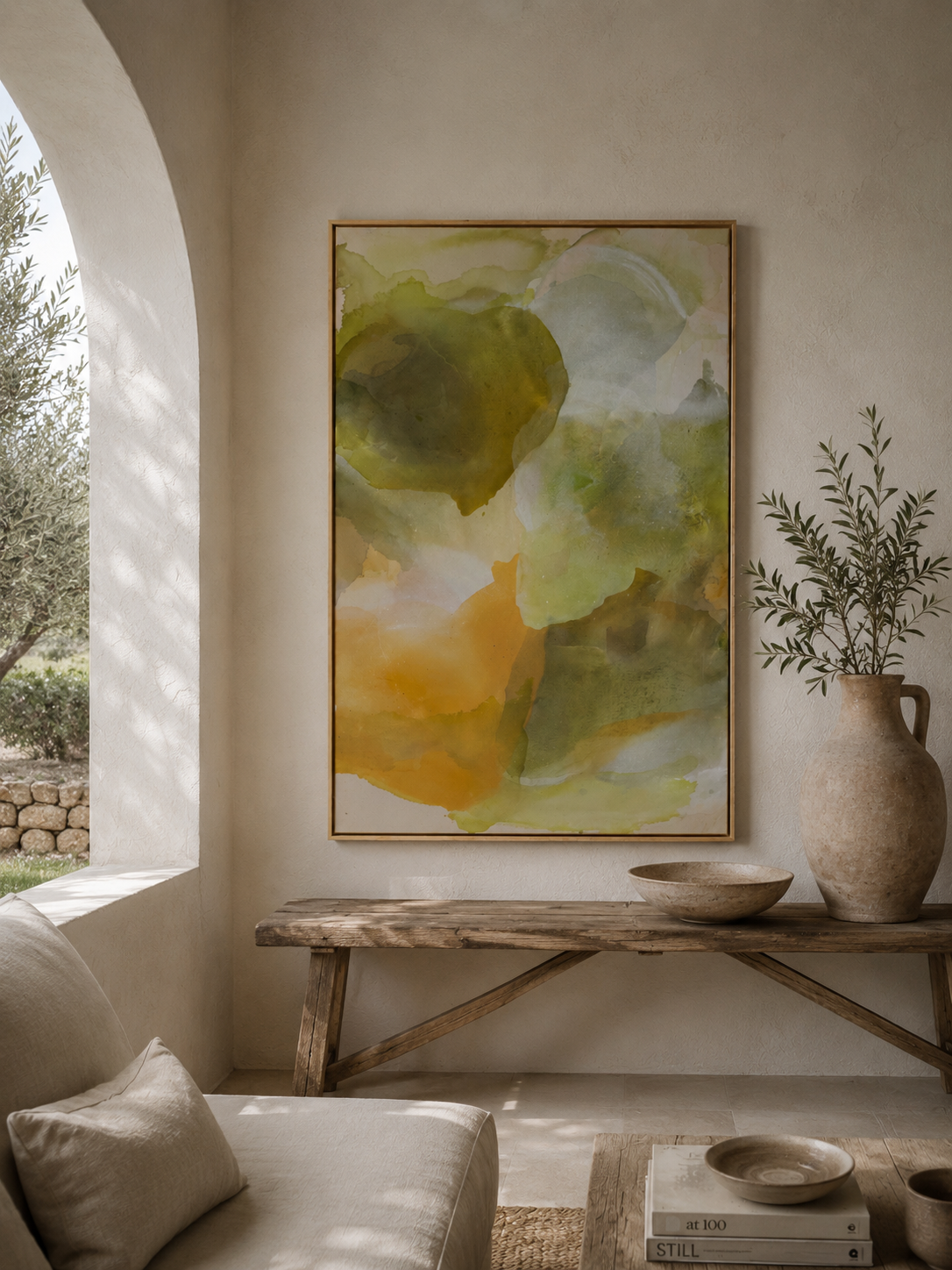 Ein Wohnzimmer mit einem großen, abstrakten Gemälde in Grüntönen an der Wand, einem Holzklapptisch mit Keramikgefäßen und einer Pflanze in einer Vase auf dem Tisch, sonnendes Licht durch ein Fenster.
