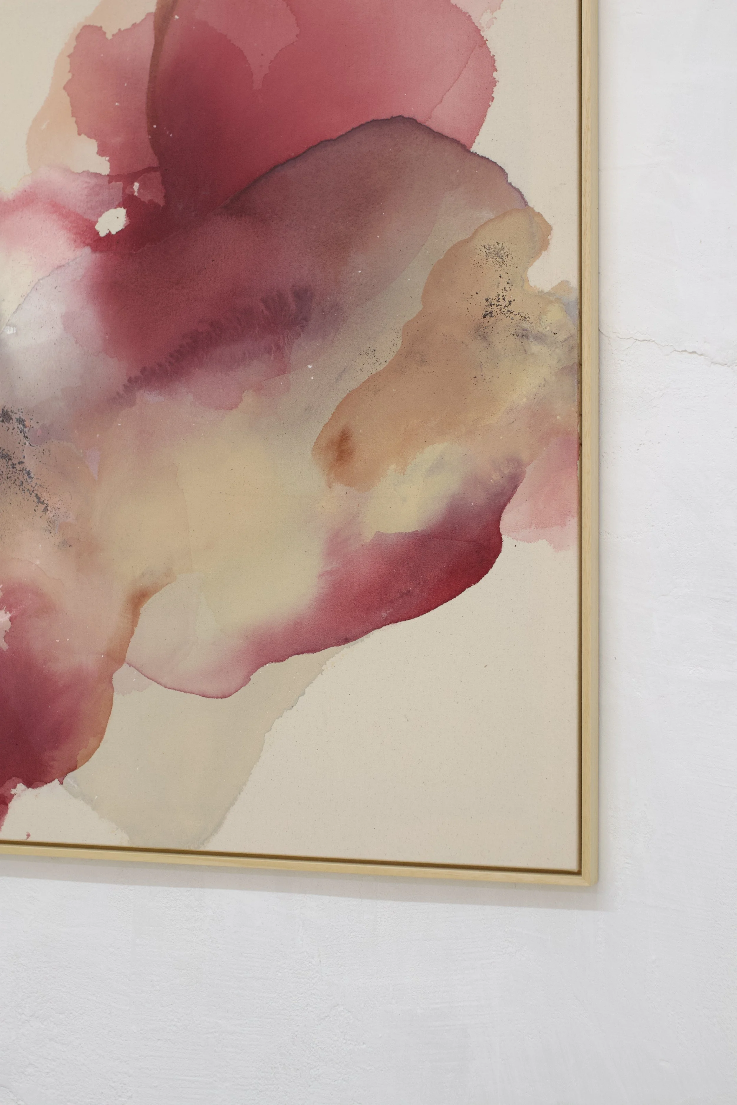 Aquarellkunstwerk mit rosa, roten, beigen und schwarzen Farbtönen, gerahmt und an einer weißen Wand aufgehängt.