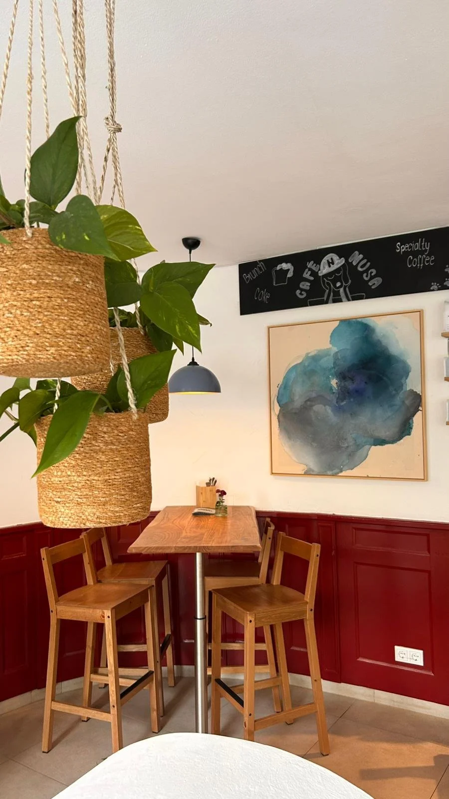 Original abstract paintings by Denize Jung displayed in the interior of Café Nusa in Weinheim, combining contemporary art with a calm and inviting atmosphere.