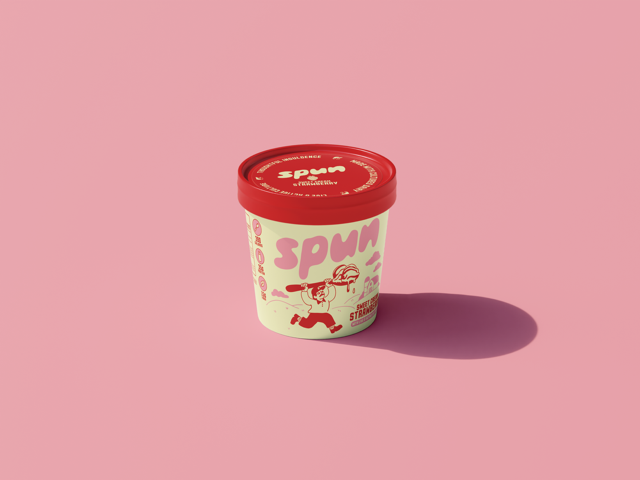A tub of strawberry flavored frozen dessert with a red lid, featuring a cartoon character holding a spoon and the word "SPUM" on the side, placed on a pink surface with a shadow.