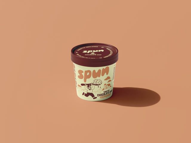 A tub of Spum ice cream with a maroon lid, placed on a peach-colored surface with its shadow to the right.