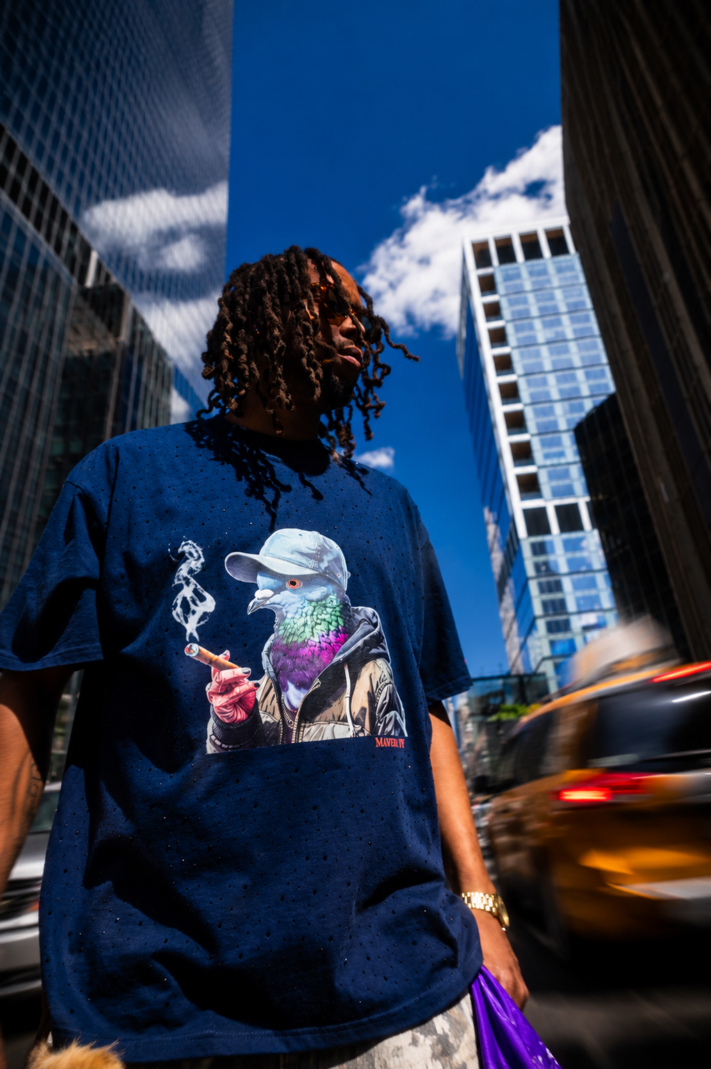 Woman wearing MXNY's navy blue pigeon graphic tee on the streets of New York City, representing Mavrix NY streetwear.