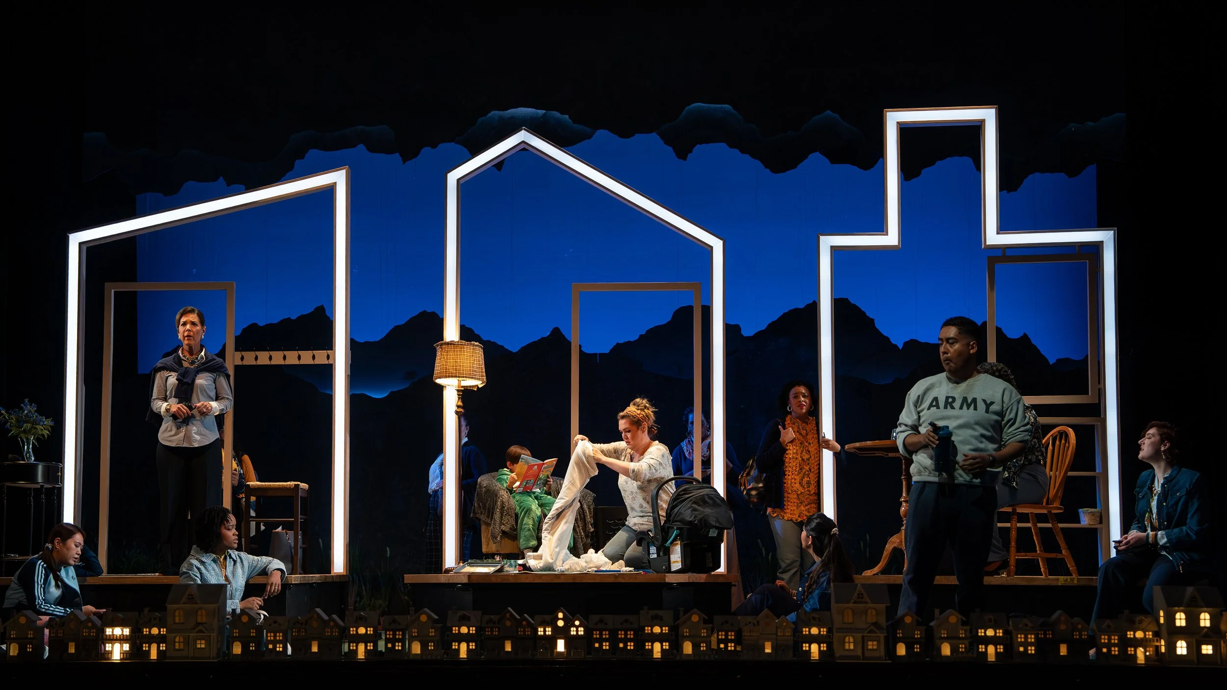 Wide-shot of the set showing all set dressing in the three houses for the opera “The Knock”