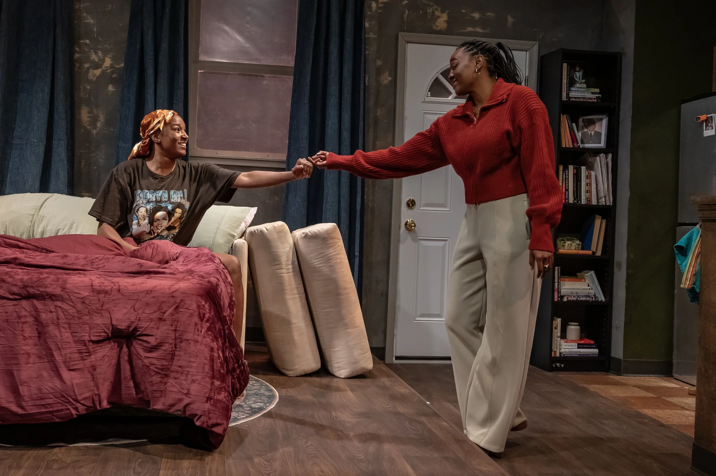Two characters in front of a bookshelf in the play “Furlough’s Paradise” by A.K. Payne