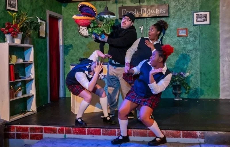 Actors with the Audrey I puppet on the set for the musical “Little Shop of Horrors” by Alan Menken and Howard Ashman