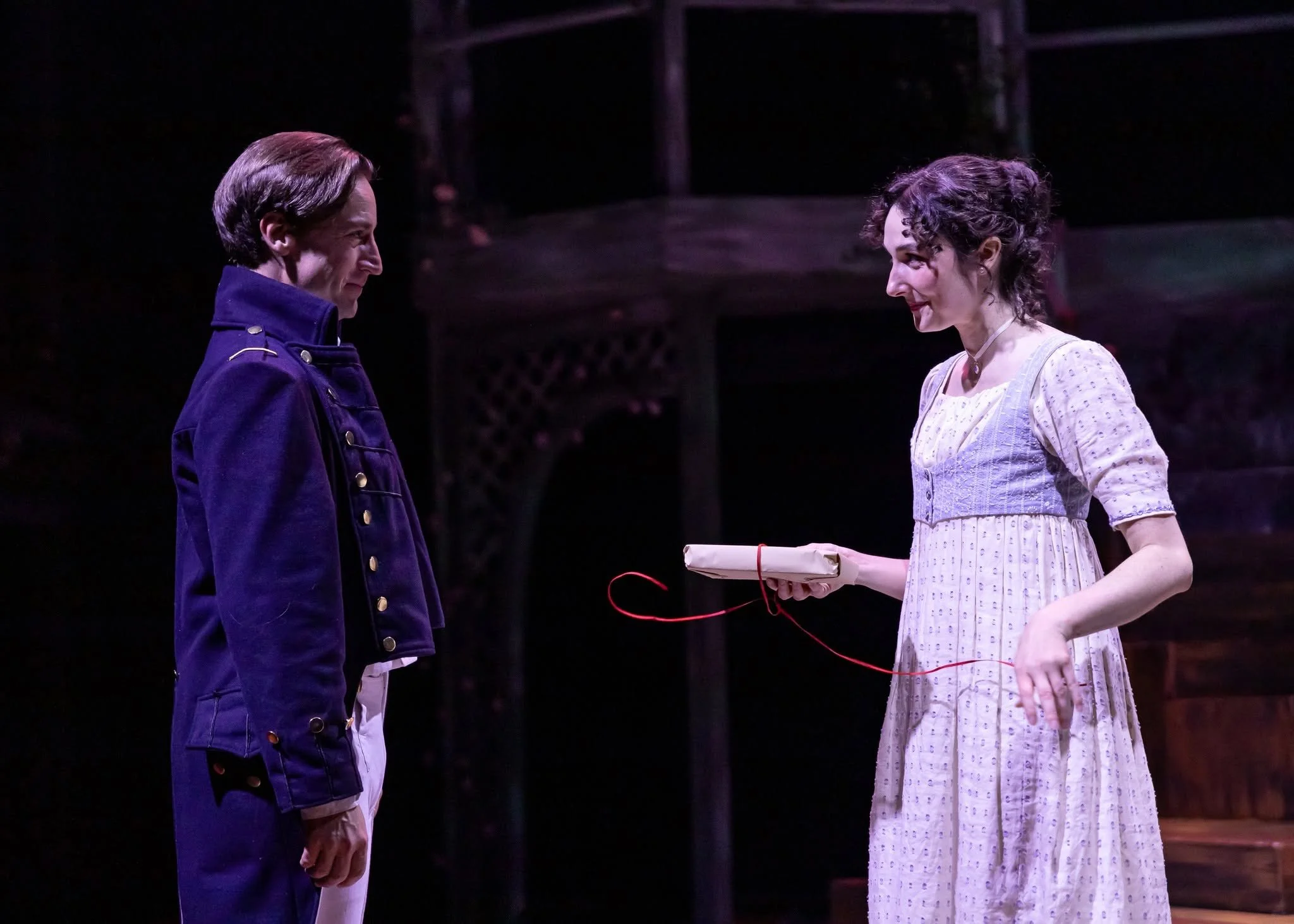 Wentworth and Anne unwrapping a gift onstage in the play “Persuasion” by Jane Austen, adapted by Sarah Rose Kearns