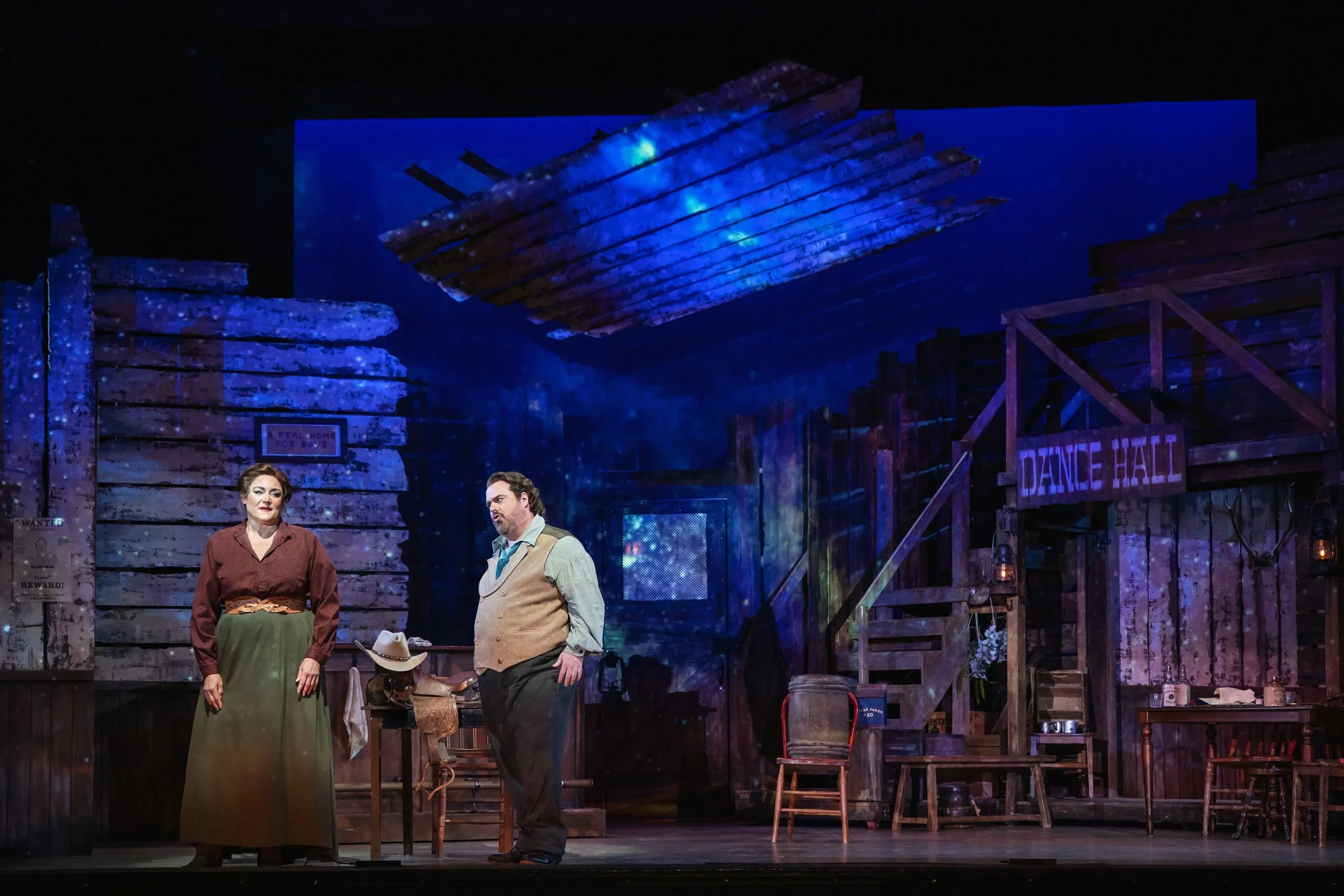 Wide-shot of the dance hall with set dressing and props for the opera “La Fanciulla del West”