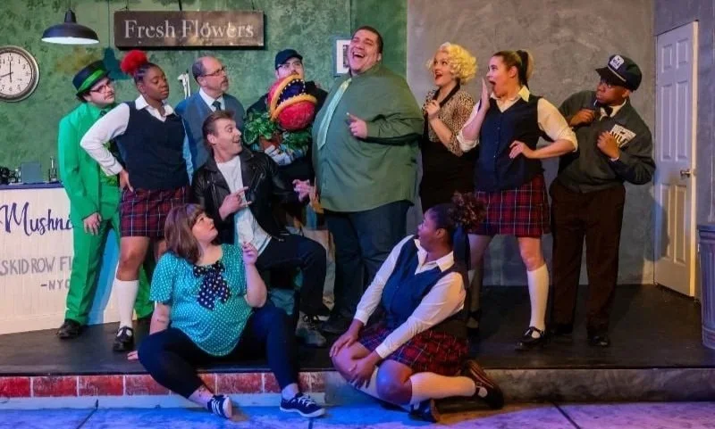 Group shot of all the actors on the set for the musical “Little Shop of Horrors” by Alan Menken and Howard Ashman
