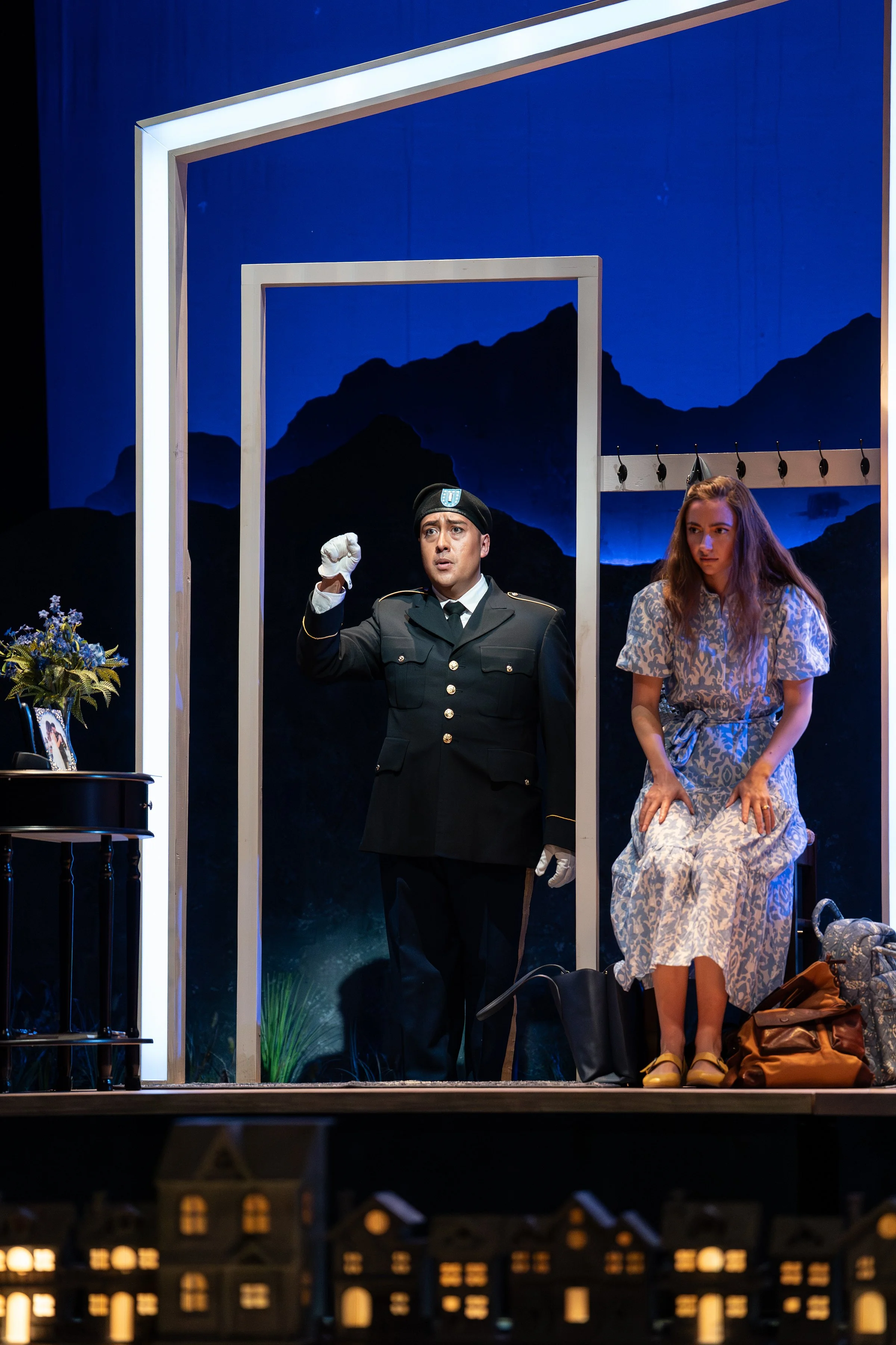 An uniformed officer entering the parlor during the opera “The Knock”