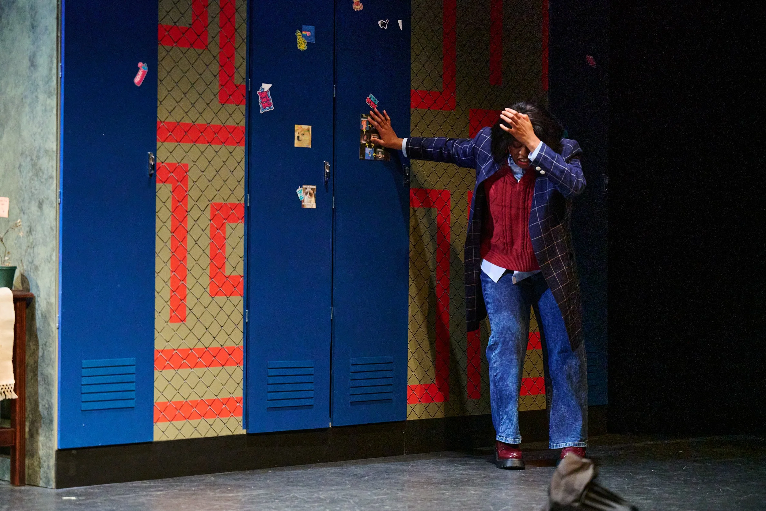 Main character leaning against the lockers frustrated in Pipeline by Dominique Morisseau