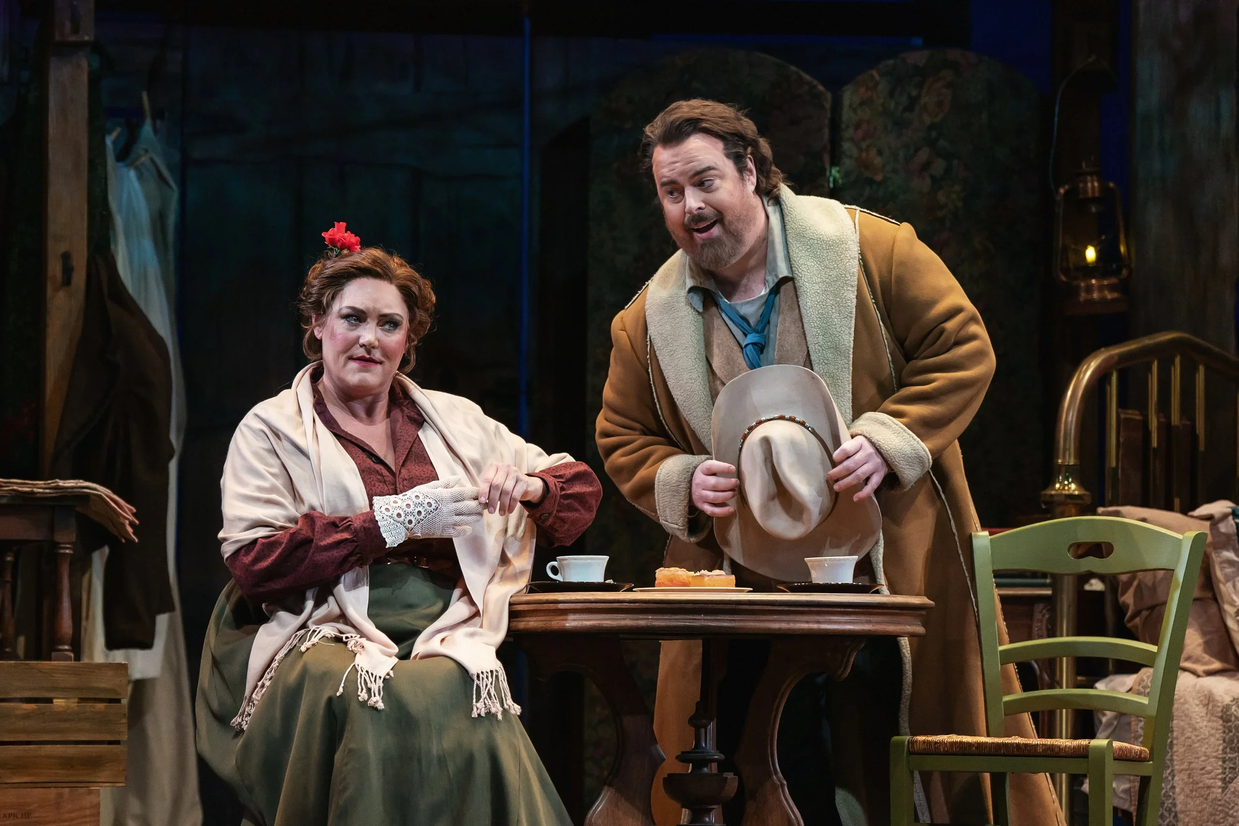 Close up of the main couple in the opera “La Fanciulla del West,” featuring a tea spread