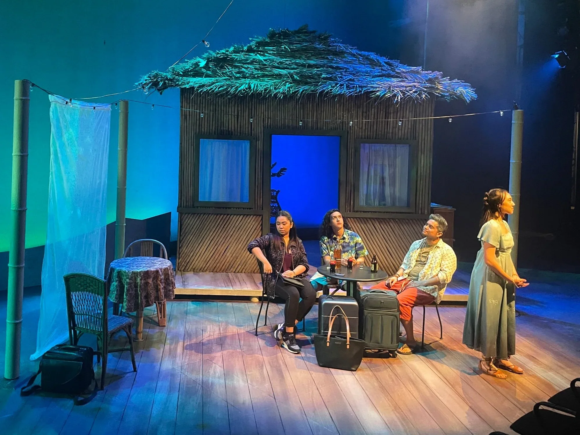 Wide shot of characters at a cafe table in the Philippines on the scenic design for the play “Bloodletting” by Boni Alvarez