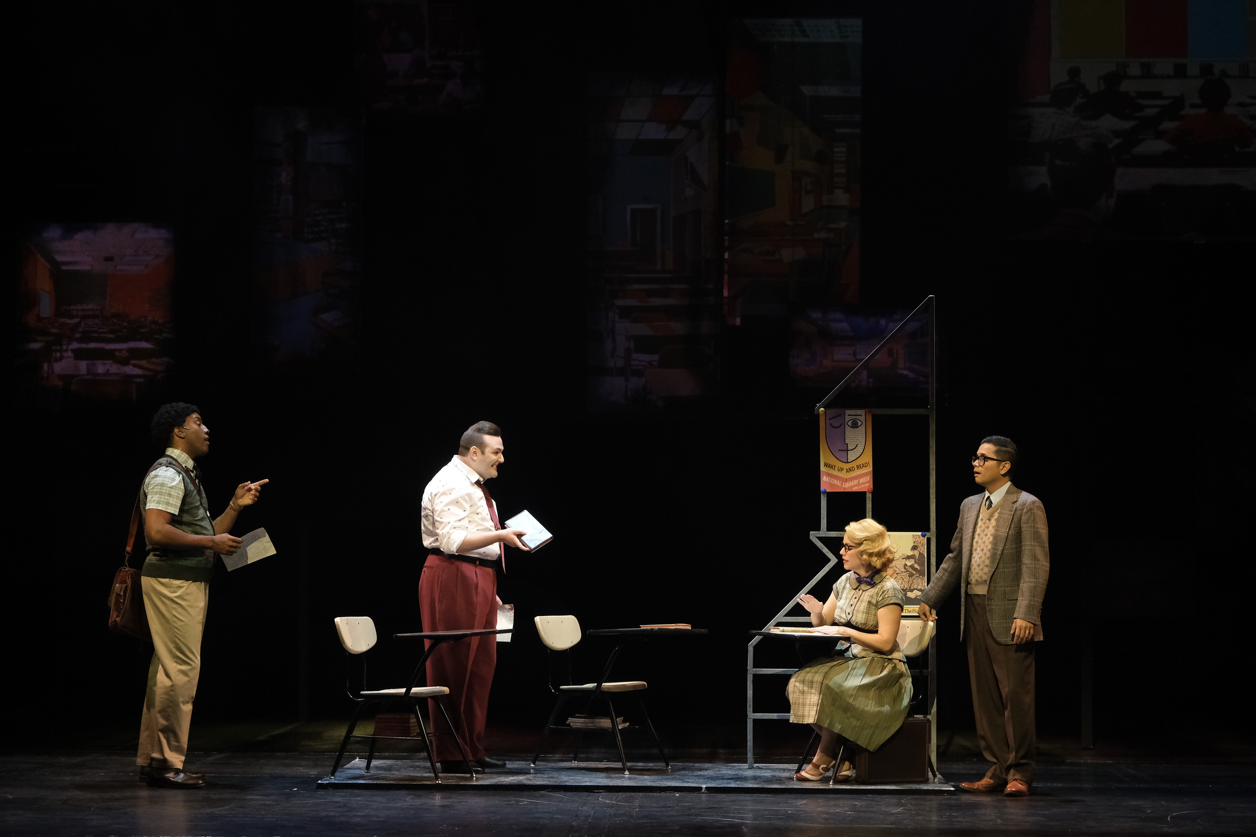 Show shot of a conversation in classroom featuring four actors on the scenic design for the world premiere musical “In a Sunshine State.”