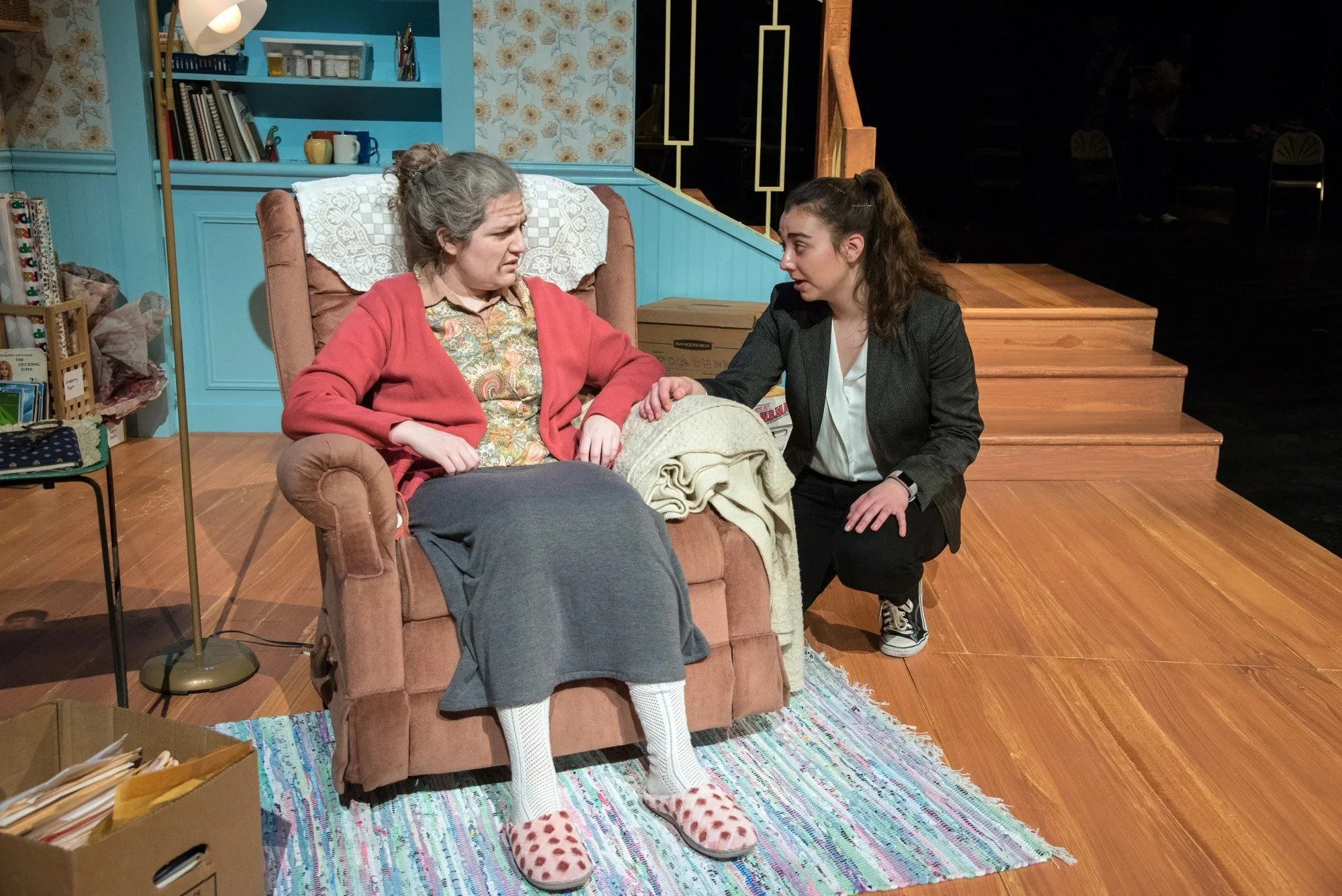 Close up of two actors around the recliner chair on the set for the play “Well” by Lisa Kron