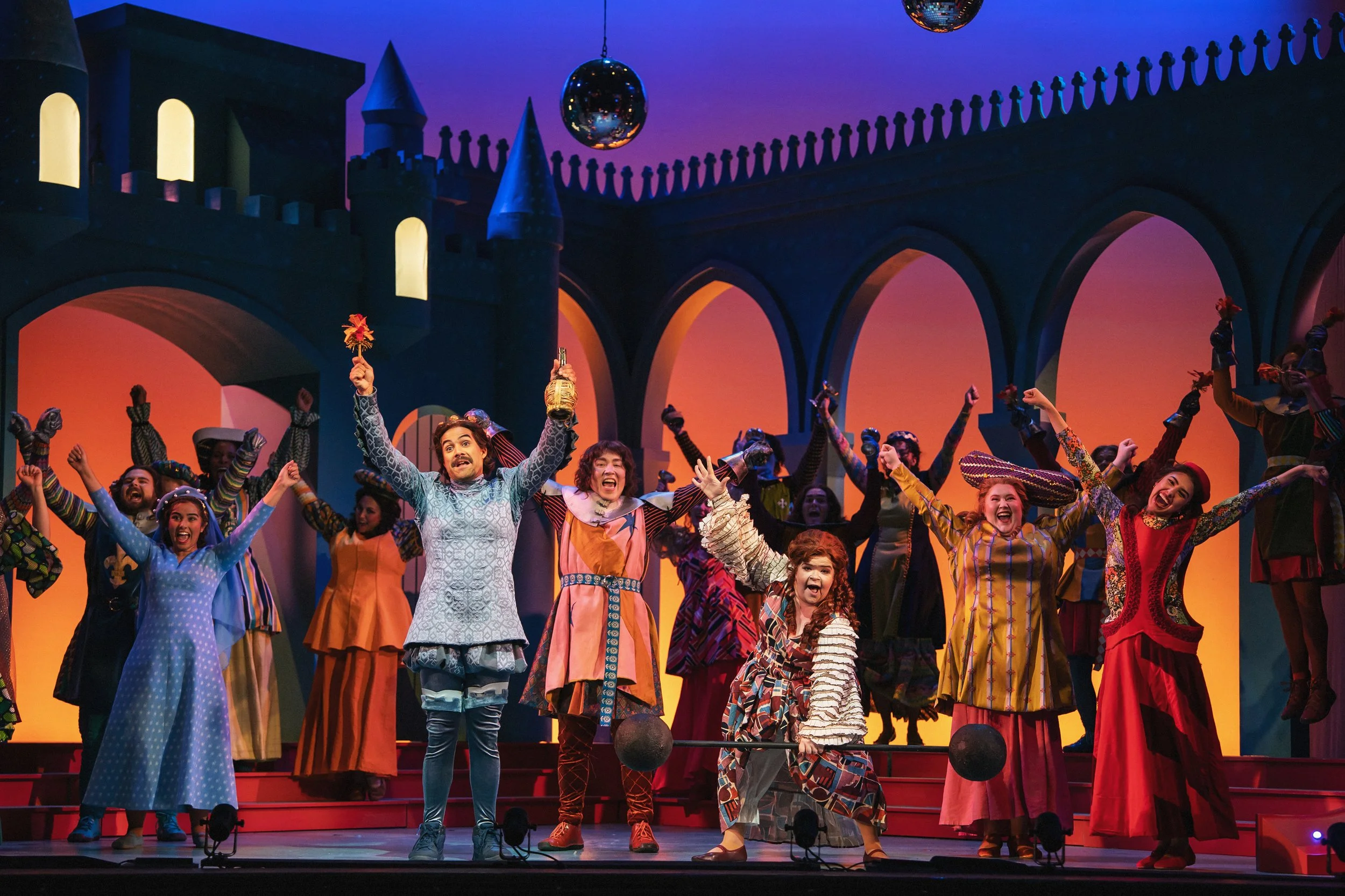A celebratory picture with a large barbell and pom-poms in the opera “Once Upon a Mattress”