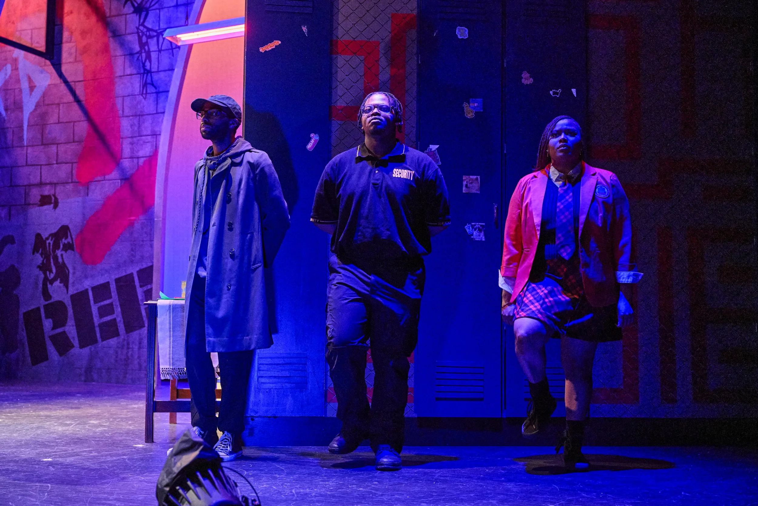 Colorful lit moment of three characters in the theater play Pipeline by Dominique Morisseau