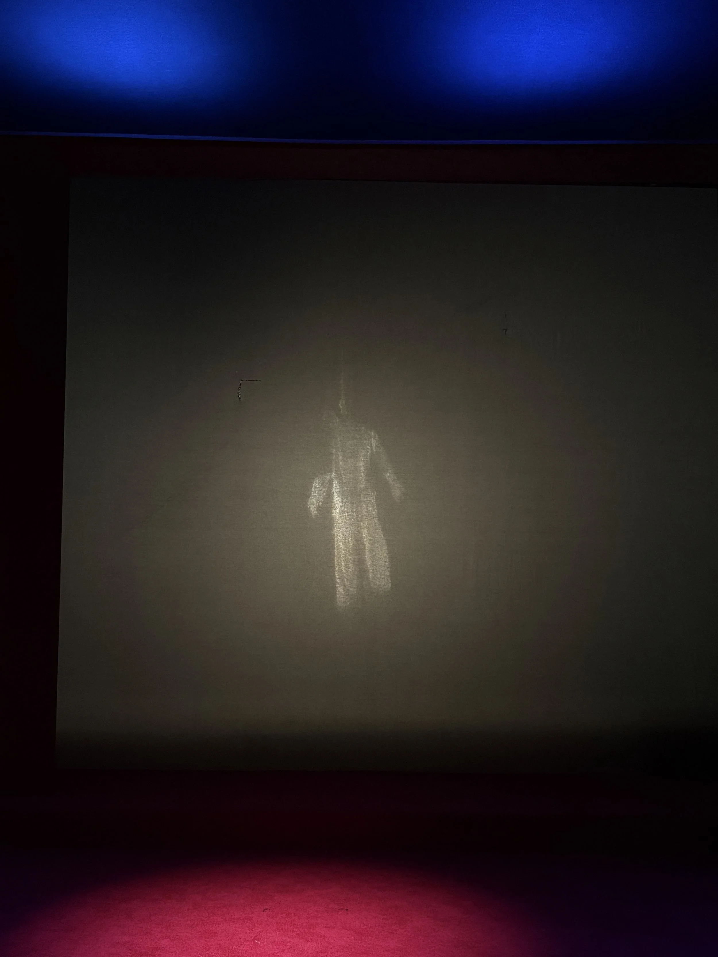 Spotlit dummy hanging behind a black scrim in the play “La Casa de Bernarda Alba” by Federico García Lorca