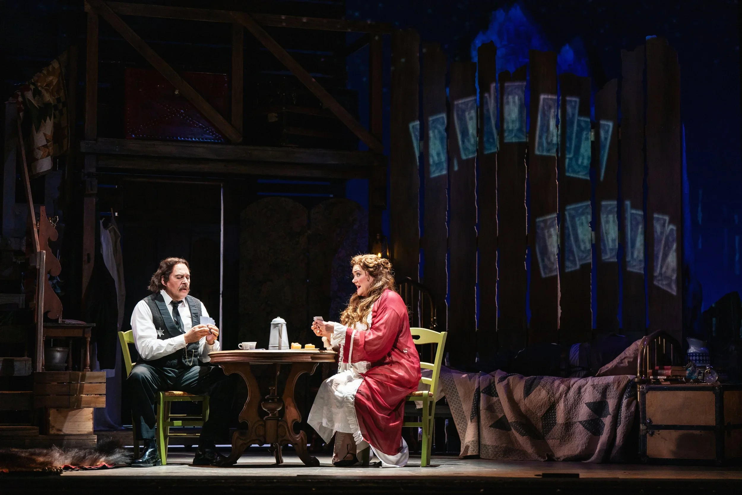 Still of a kitchen table conversation in the house set of the opera “La Fanciulla del West”