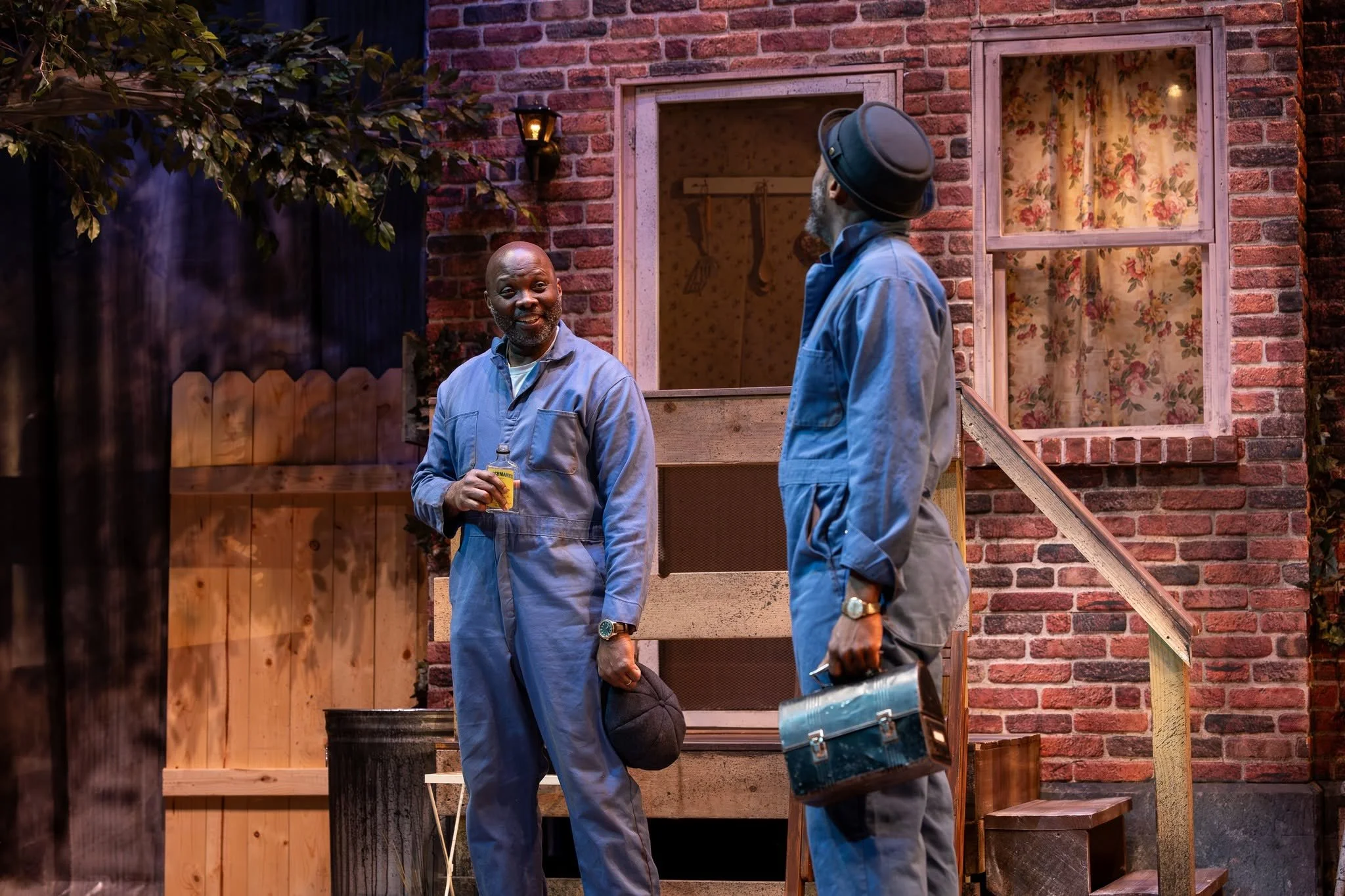 Close-up of Bono and Troy with bottles and lunchboxes onstage in the play “Fences” by August Wilson