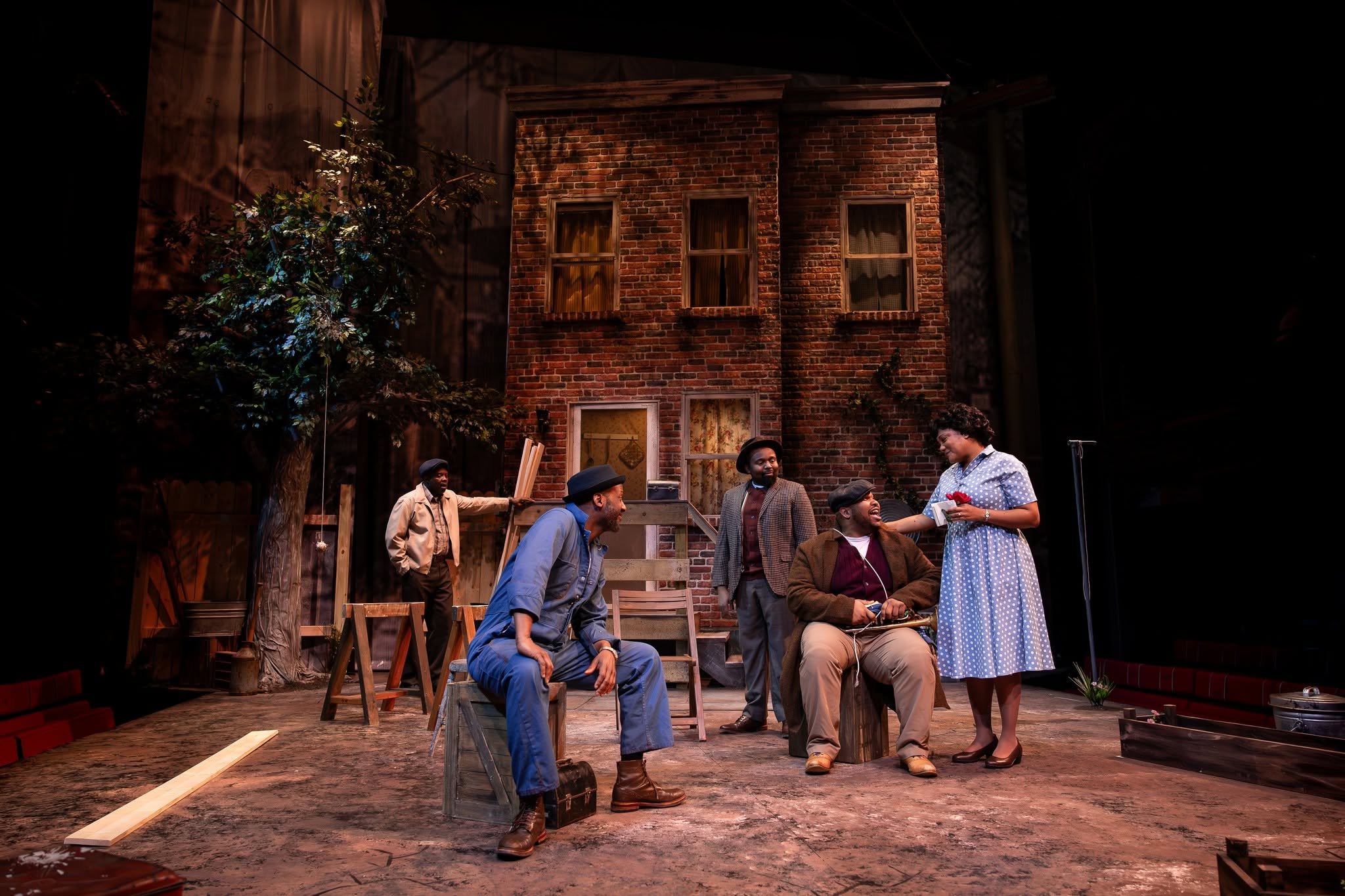 A wide-shot of the yard and characters in the play “Fences” by August Wilson