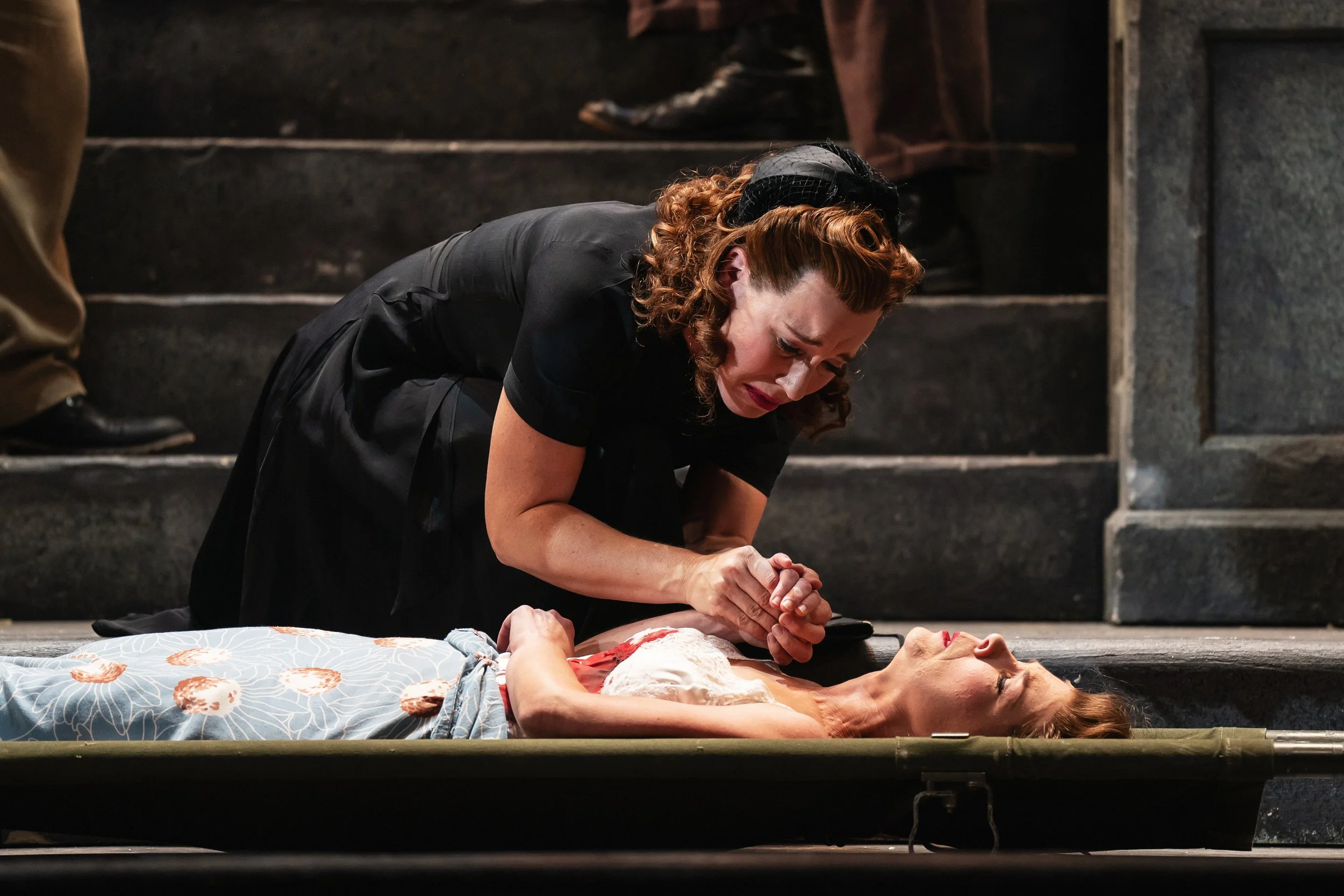 A daughter grieving her dead mother lying on a stretcher in the opera “Street Scene”