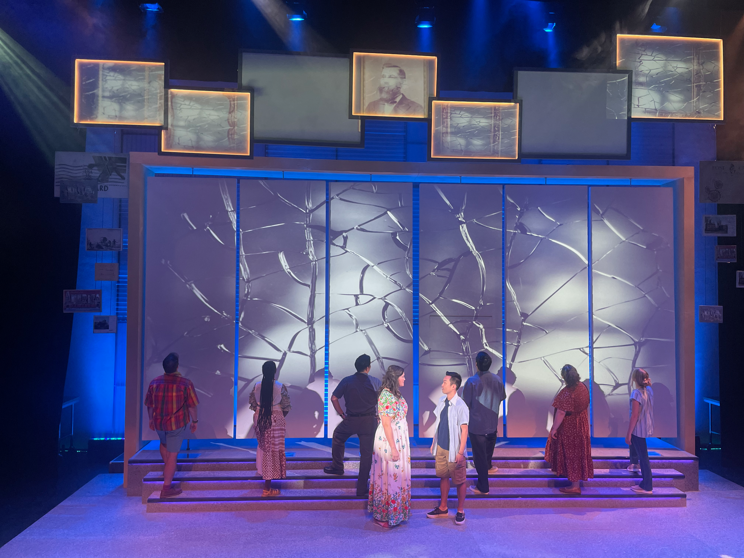 Cast looking up at projection design for the world premiere musical “Postcard American Town”