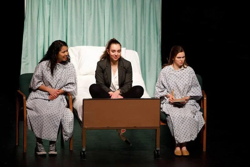 Close up of three actors gathered on a hospital bed for the play “Well” by Lisa Kron