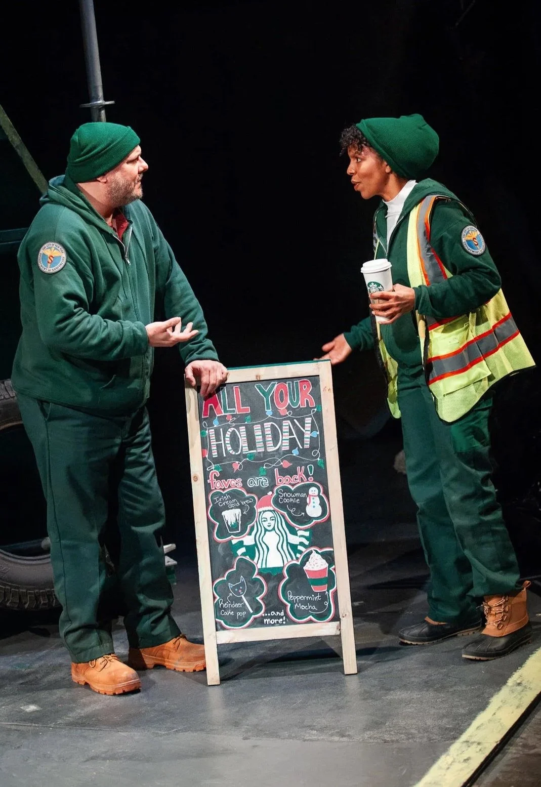 Actors interacting with the hand painted coffee shop sign in the play “The Garbologists” by Lindsay Joelle