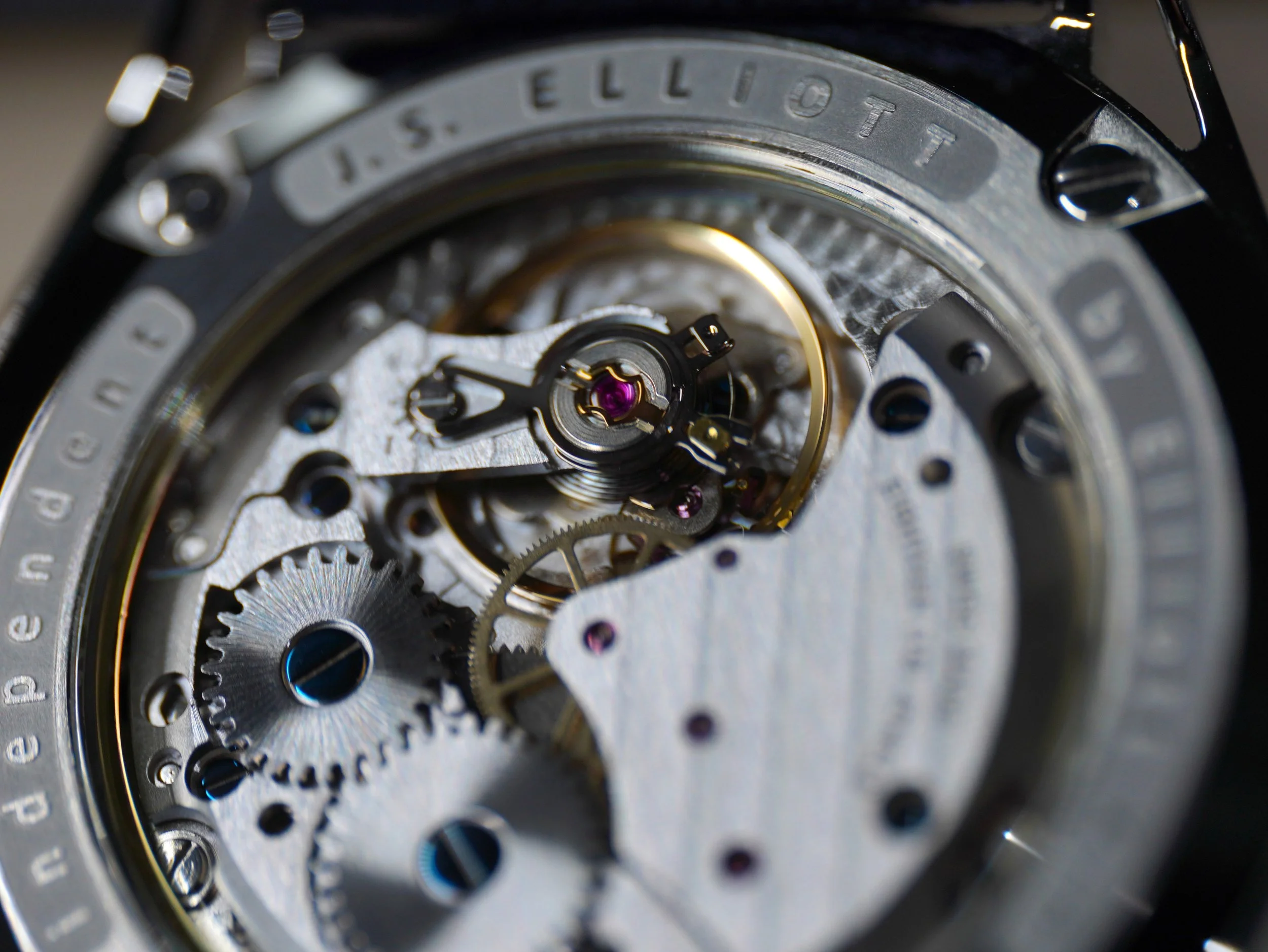 Close-up of the intricate inner mechanism of a wristwatch, showing gears, screws, and components of the watch movement.