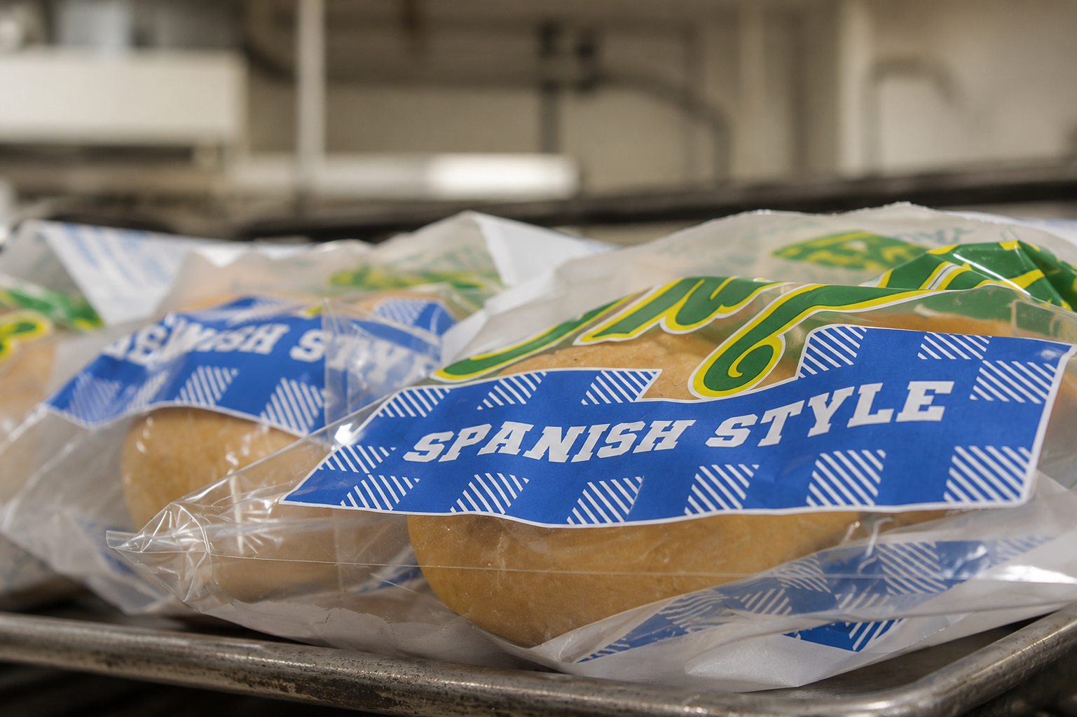 Packaged Spanish style bread rolls on a tray.
