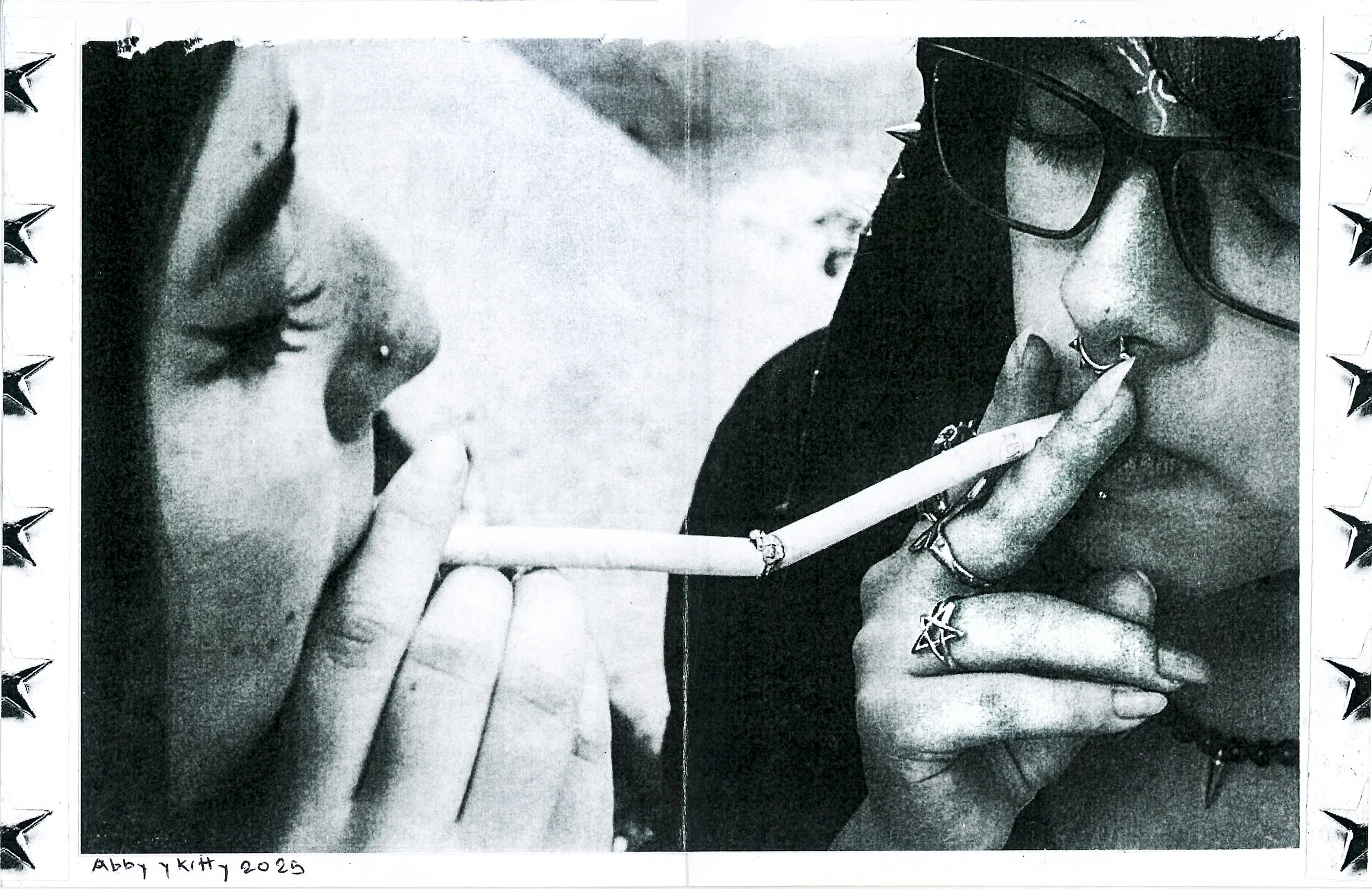 Dos personas con peinados y accesorios alternativos, una con gafas y múltiples piercings, ambas con dedos sobre los labios en una pose de silencio.