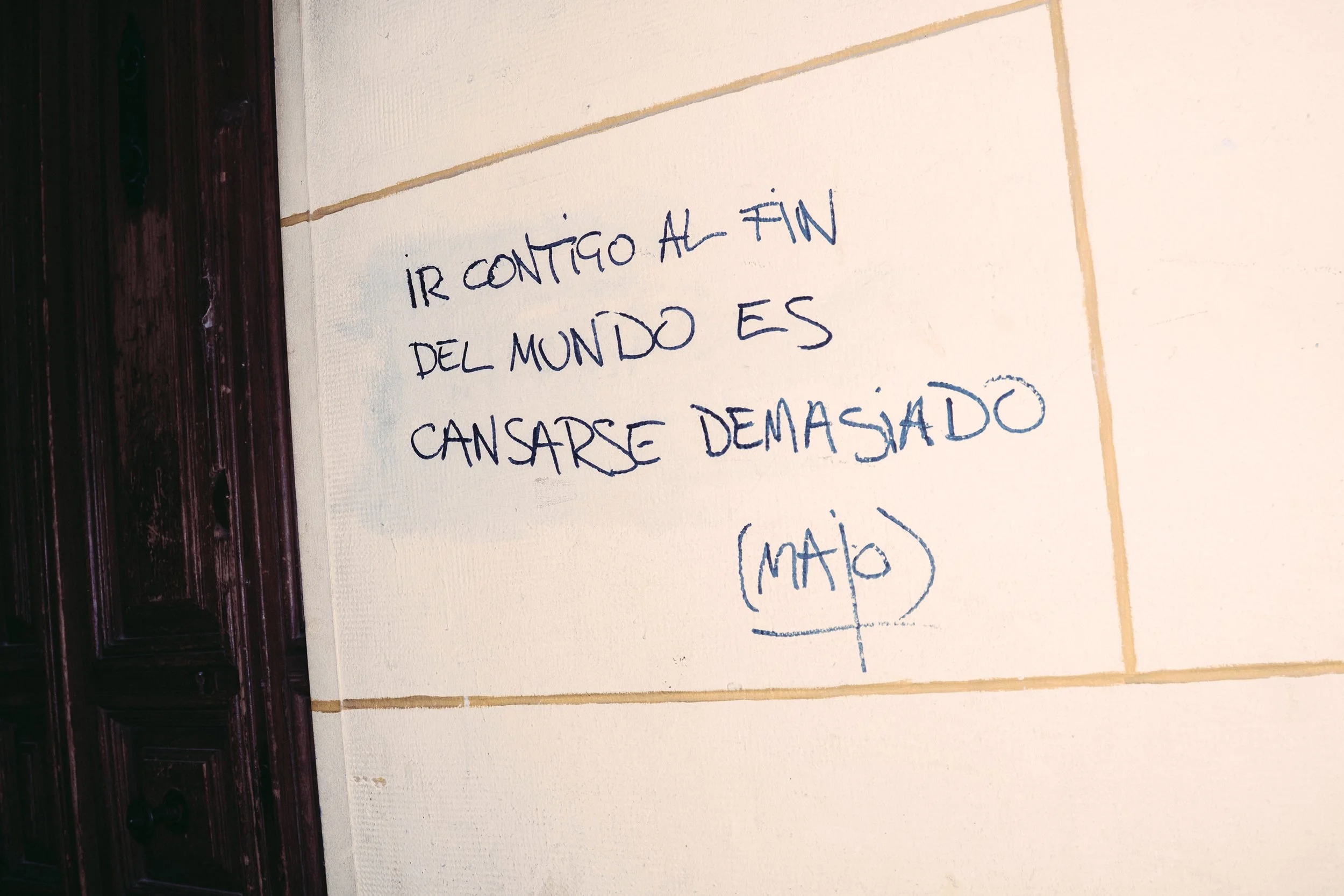 Mensaje escrito en la pared que dice: 'Ir contigo al fin del mundo es cansarse demasiado'
