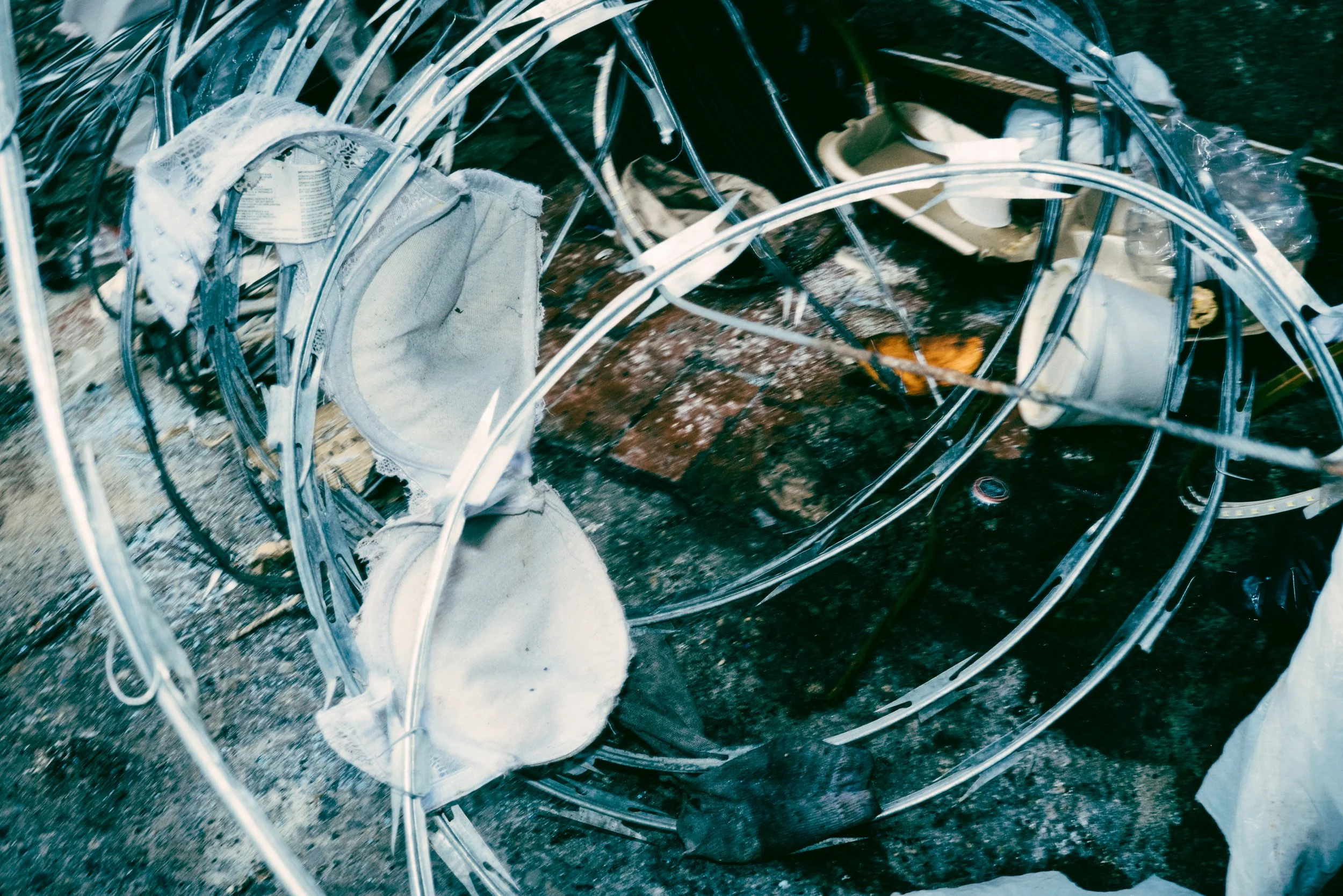 Restos de una estructura metálica dañada, con objetos y basura esparcidos.