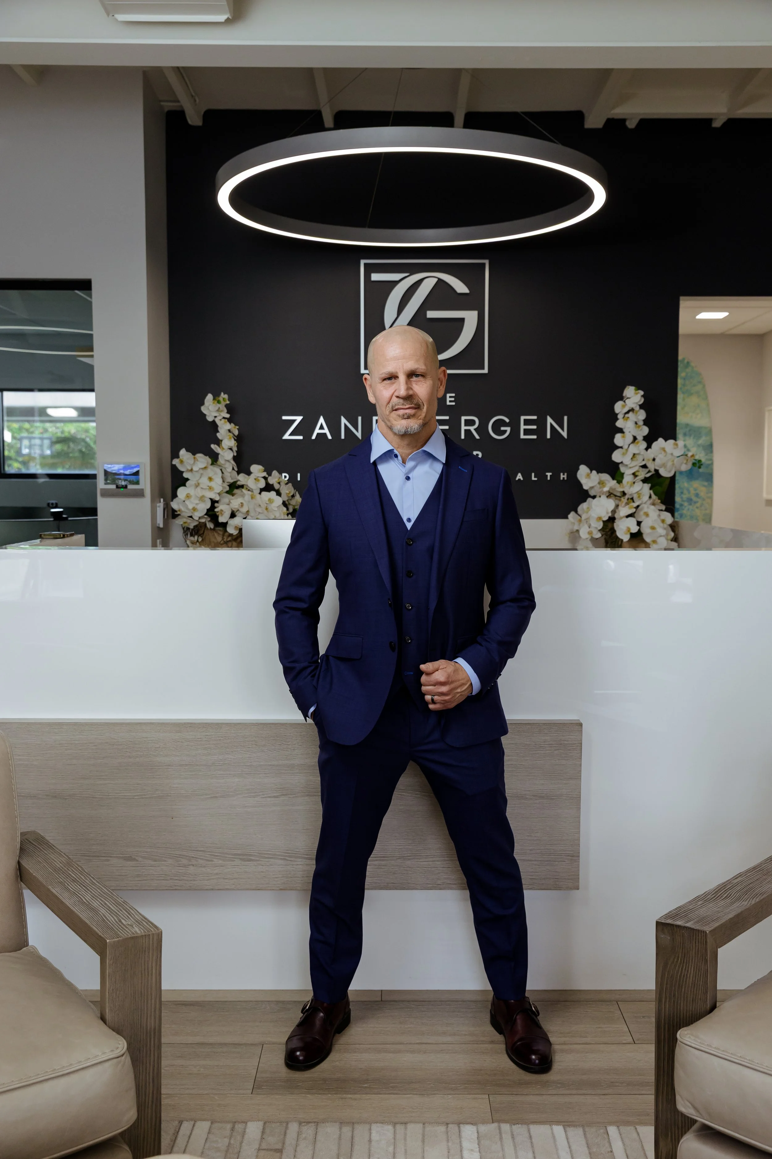 Tony Kakuk CFP® business owner wealth advisor standing in Zandbergen Group reception Orange County