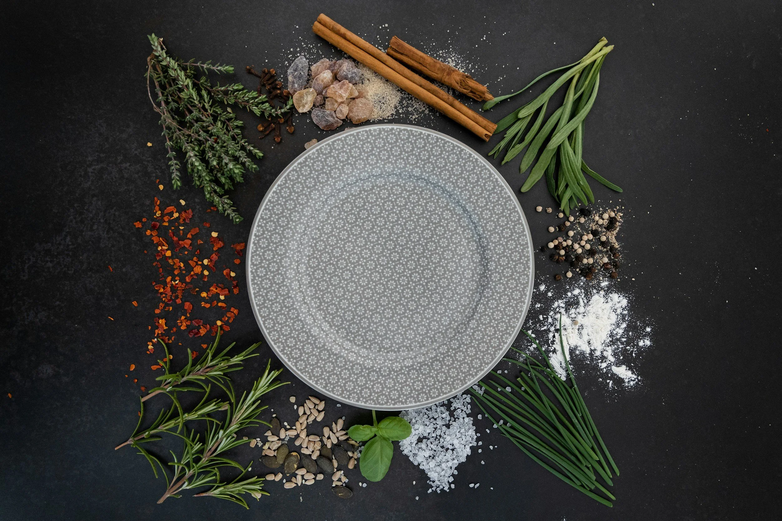 An empty dinner plate surrounded by ingredients