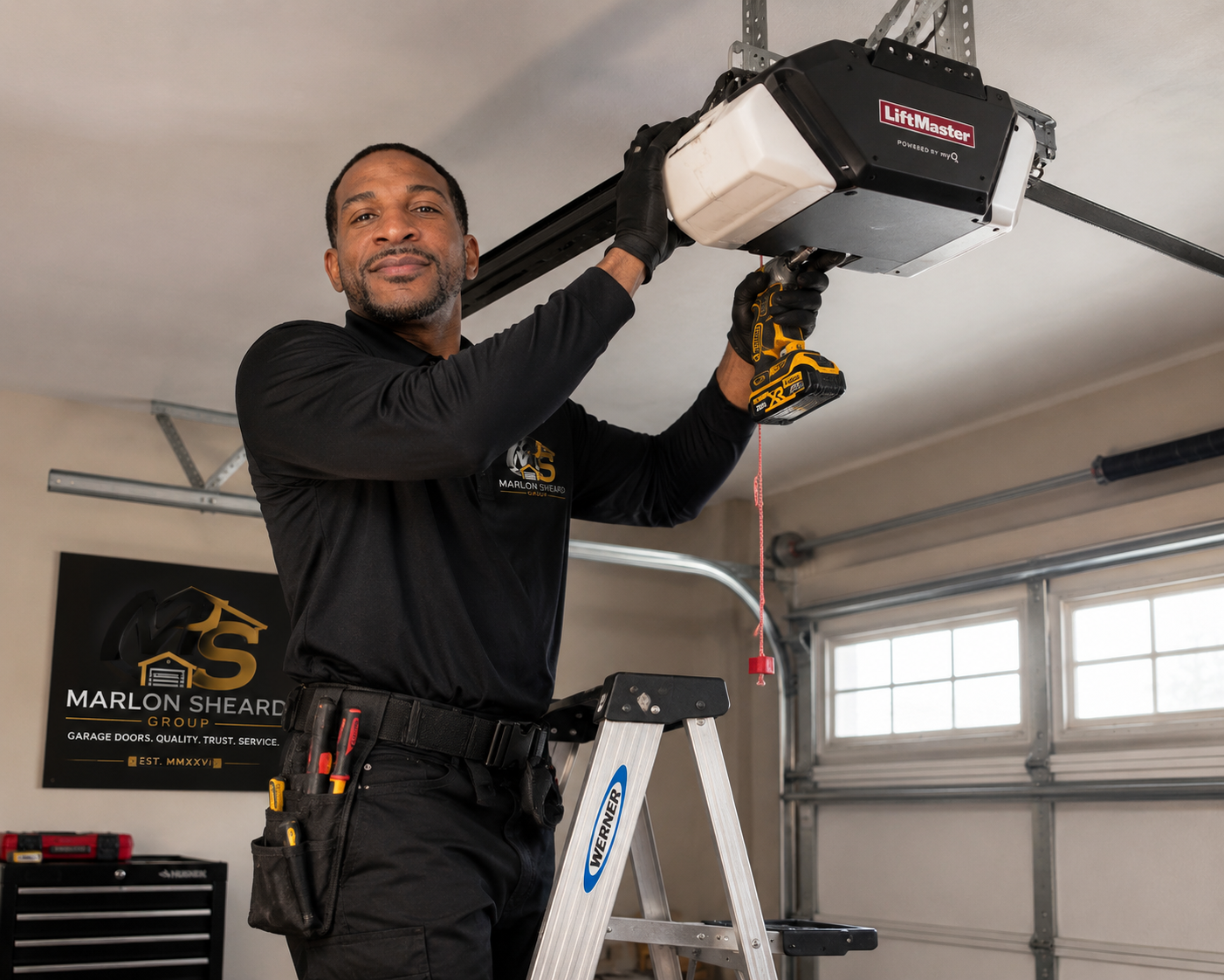 A handyman working on a garage door opener while standing on a ladder in a garage.