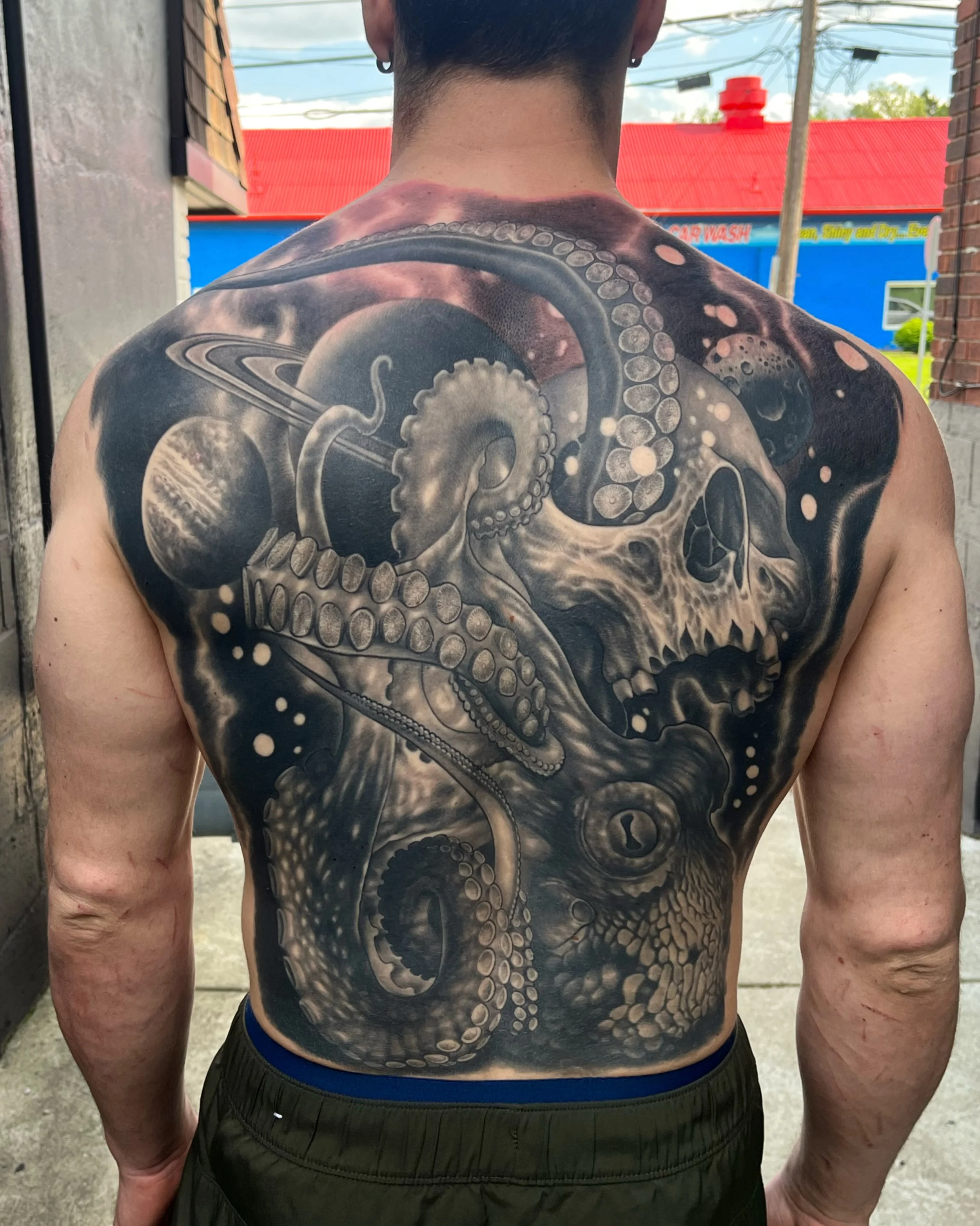 A black and gray full back tattoo featuring space and octopus tentacles by Jesse Smith in Bethel Park, PA.