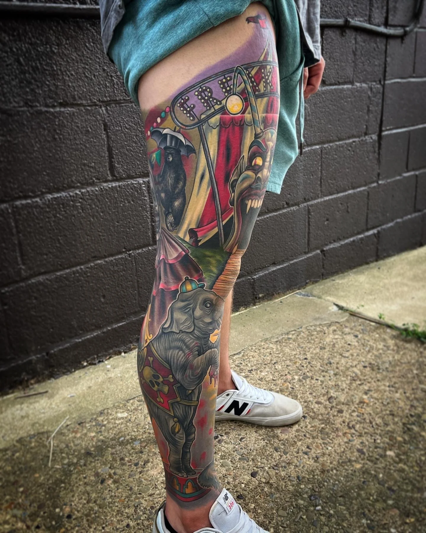 Colorful tattoo sleeve on a person's leg featuring carnival by Jesse Smith tattoo artist at Human Production Gallery in Bethel Park, PA.