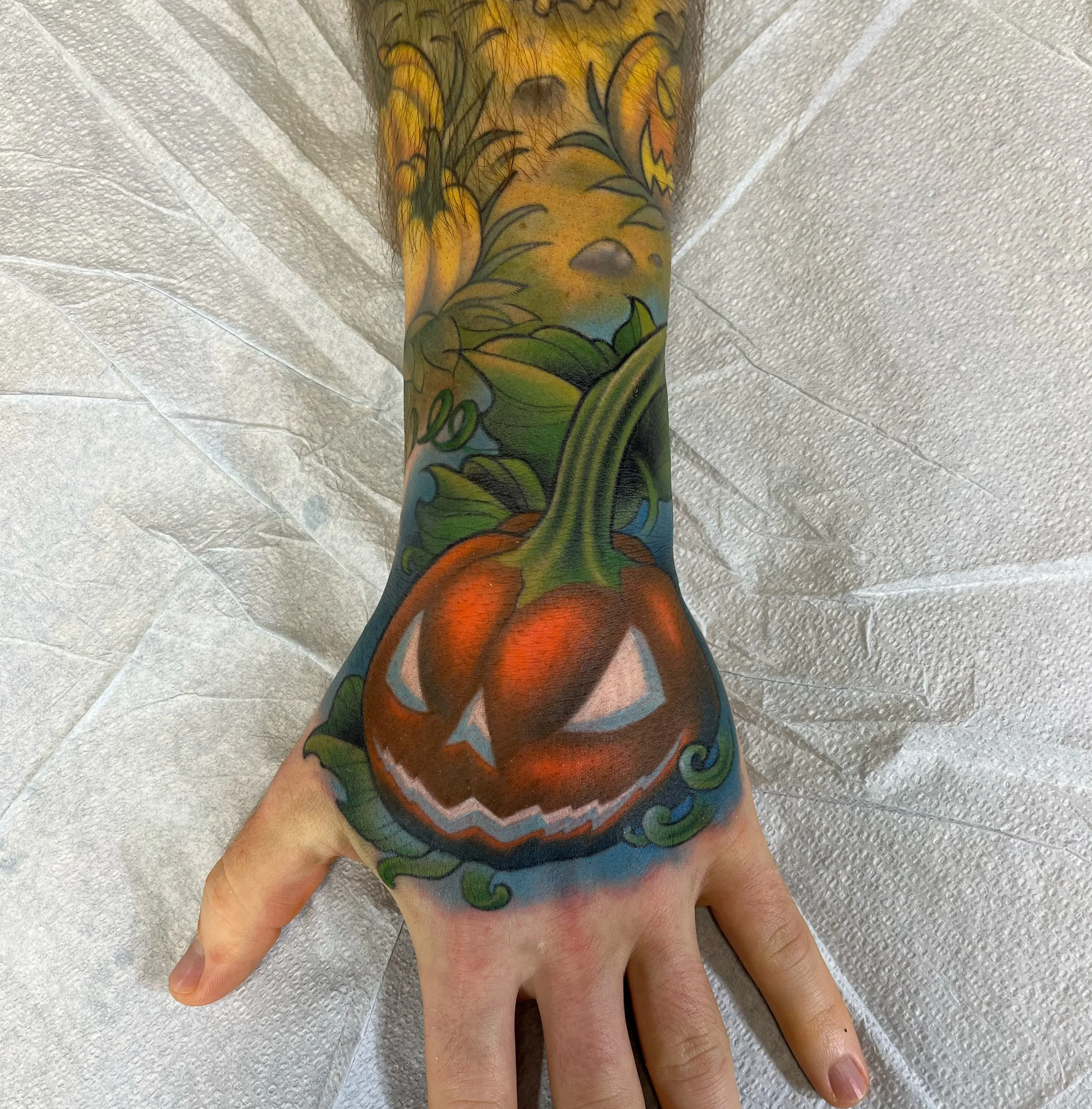 Jack-o-lantern hand tattoo by Jesse Smith, tattoo artist at Human Production Gallery in Bethel Park, PA.