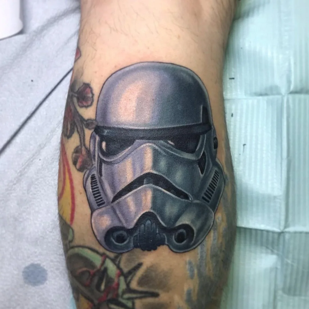 Tattoo of a Stormtrooper helmet from Star Wars on a person's arm by Jesse Smith at Human Production Gallery in Bethel Park, PA.