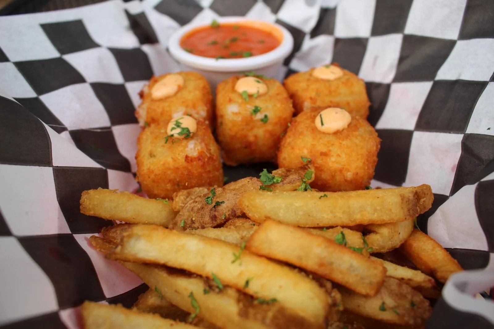 Croquetas de queso con salsa y papas a la francesa.