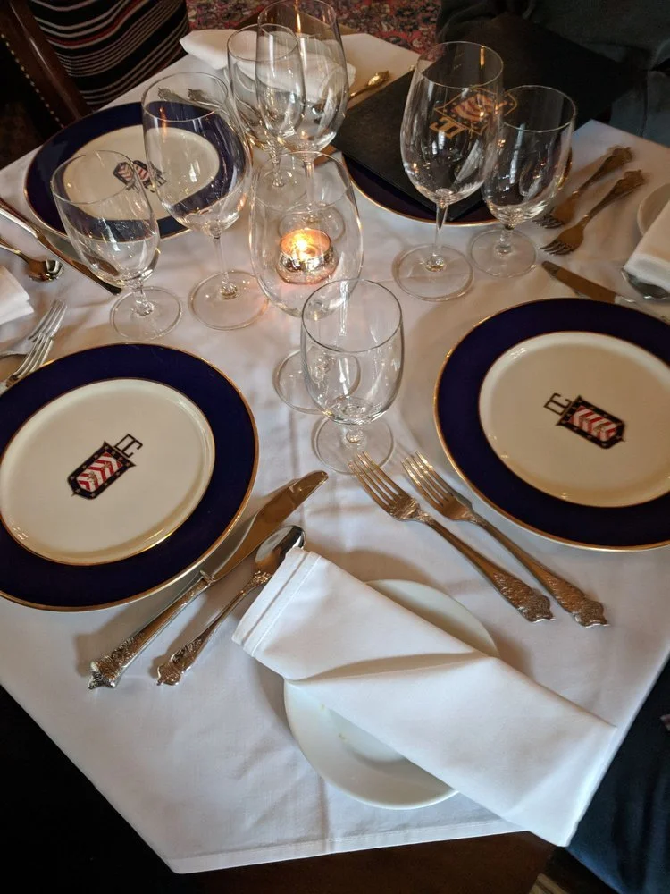 Elegant place setting with wine glasses and crested plates at Bohemia, inside the historic Detroit Clublaceholder