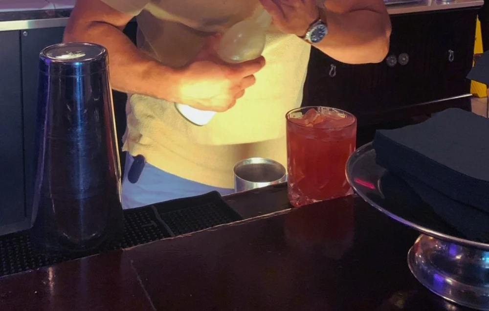 A cocktail being built at the bar