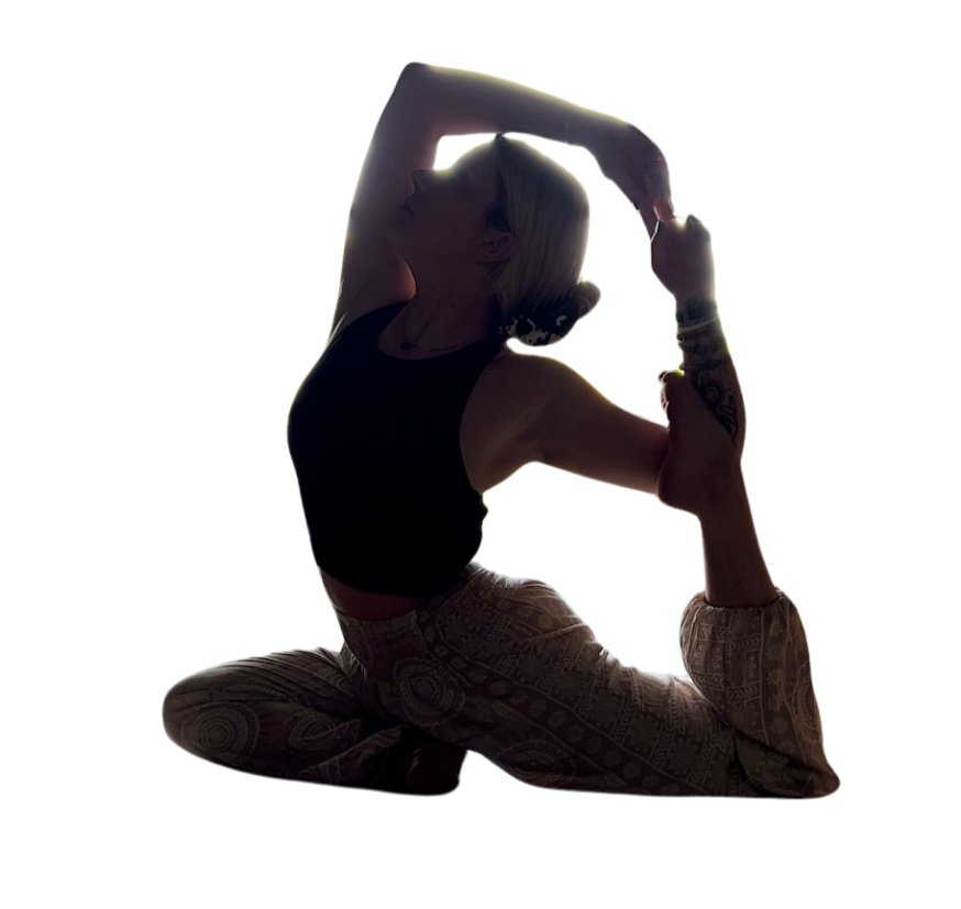 A woman practicing yoga, performing a pose with one leg bent and the other extended behind her, holding her foot with one hand and stretching her neck. She has blonde hair and tattoos on her arm, wearing a black top and patterned pants.