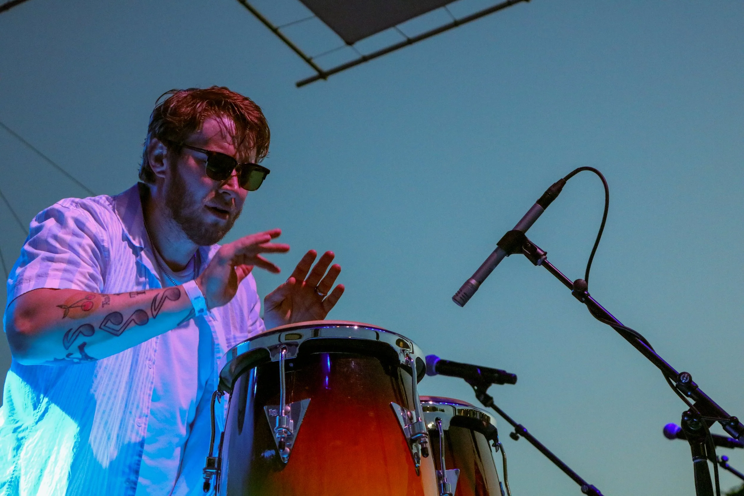 Tye of The Groove Merchants plays the drums during a live performance