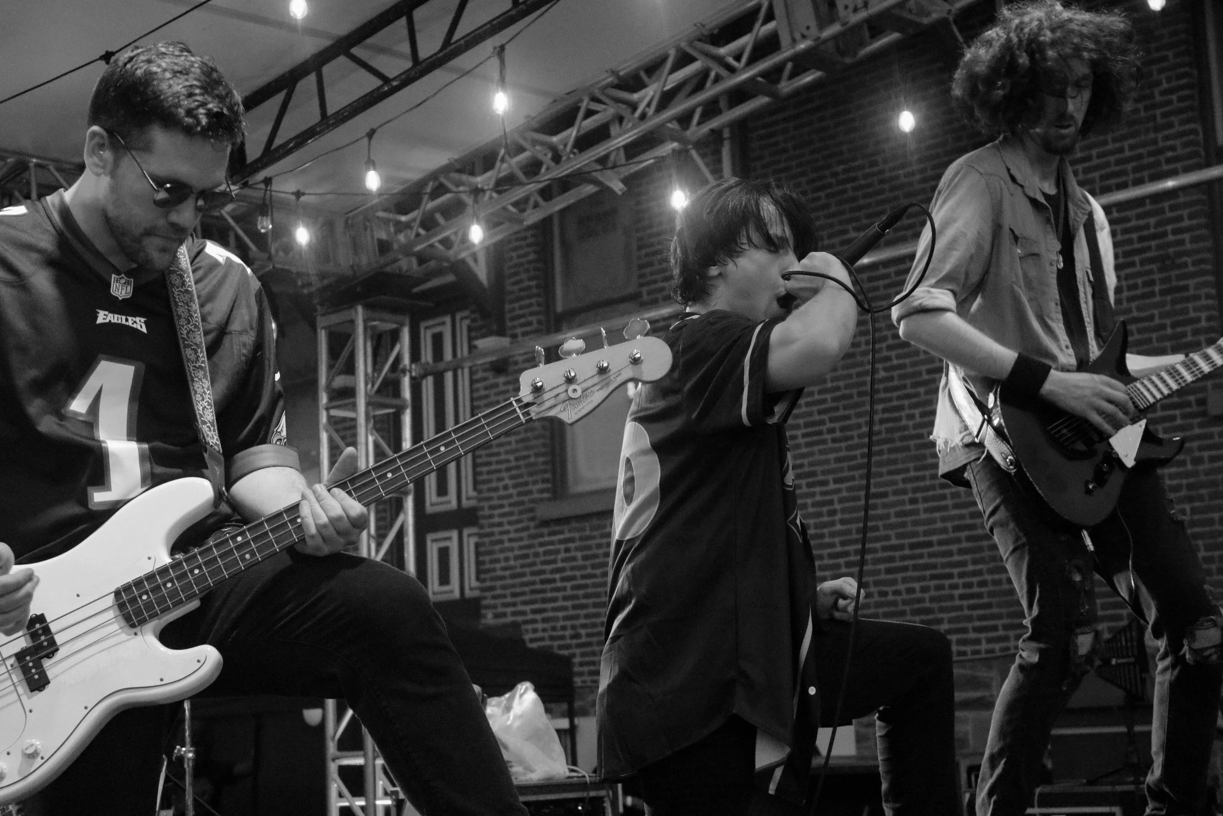 Crooked Ways perform live on stage in a black-and-white photograph